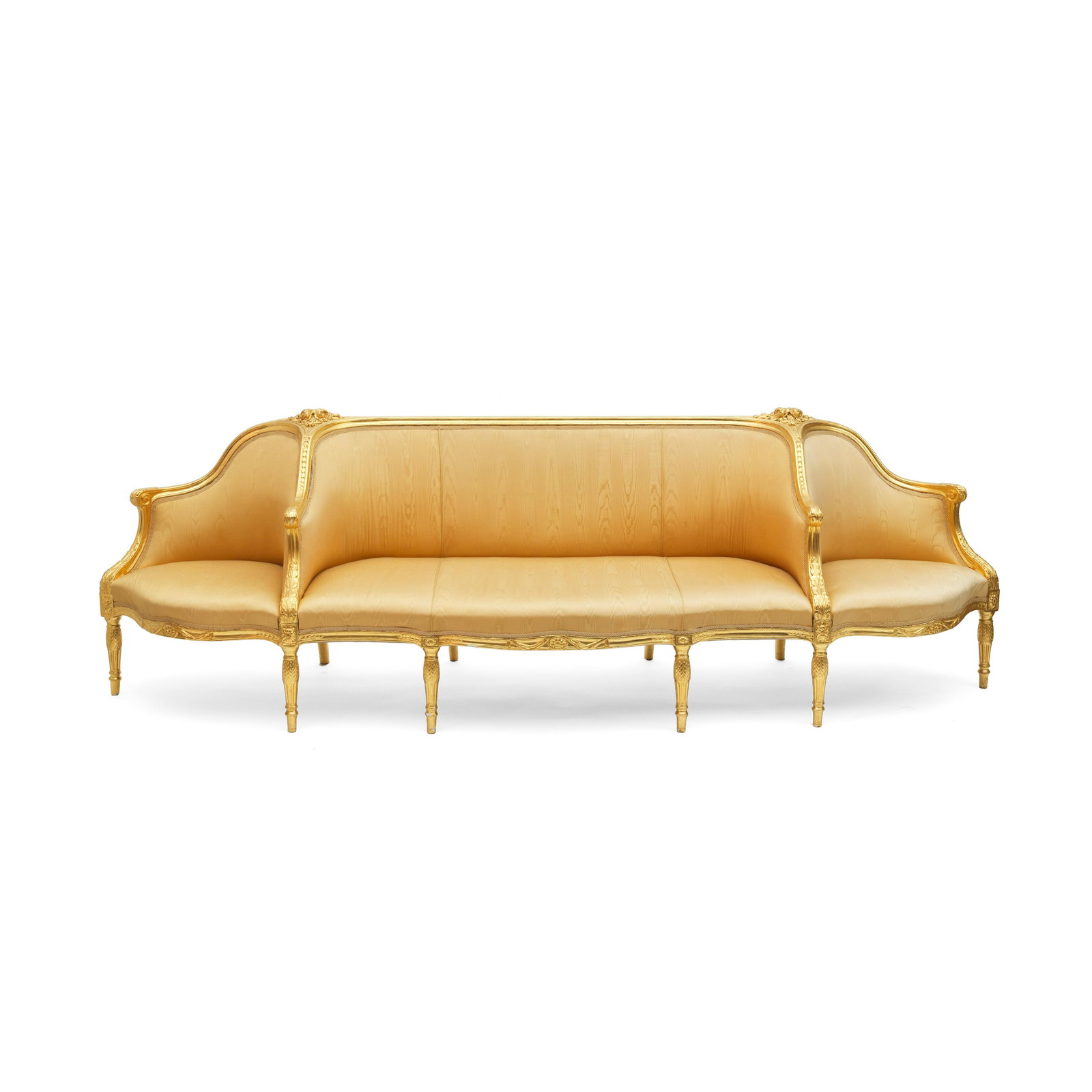 A George III carved giltwood confidante sofa In the: A GEORGE III CARVED GILTWOOD CONFIDANTE SOFA In the manner of Thomas Chippendale, circa 1770 The serpentine frame carved with flower heads and trailing bellflowers, the down swept arms with acanthus,