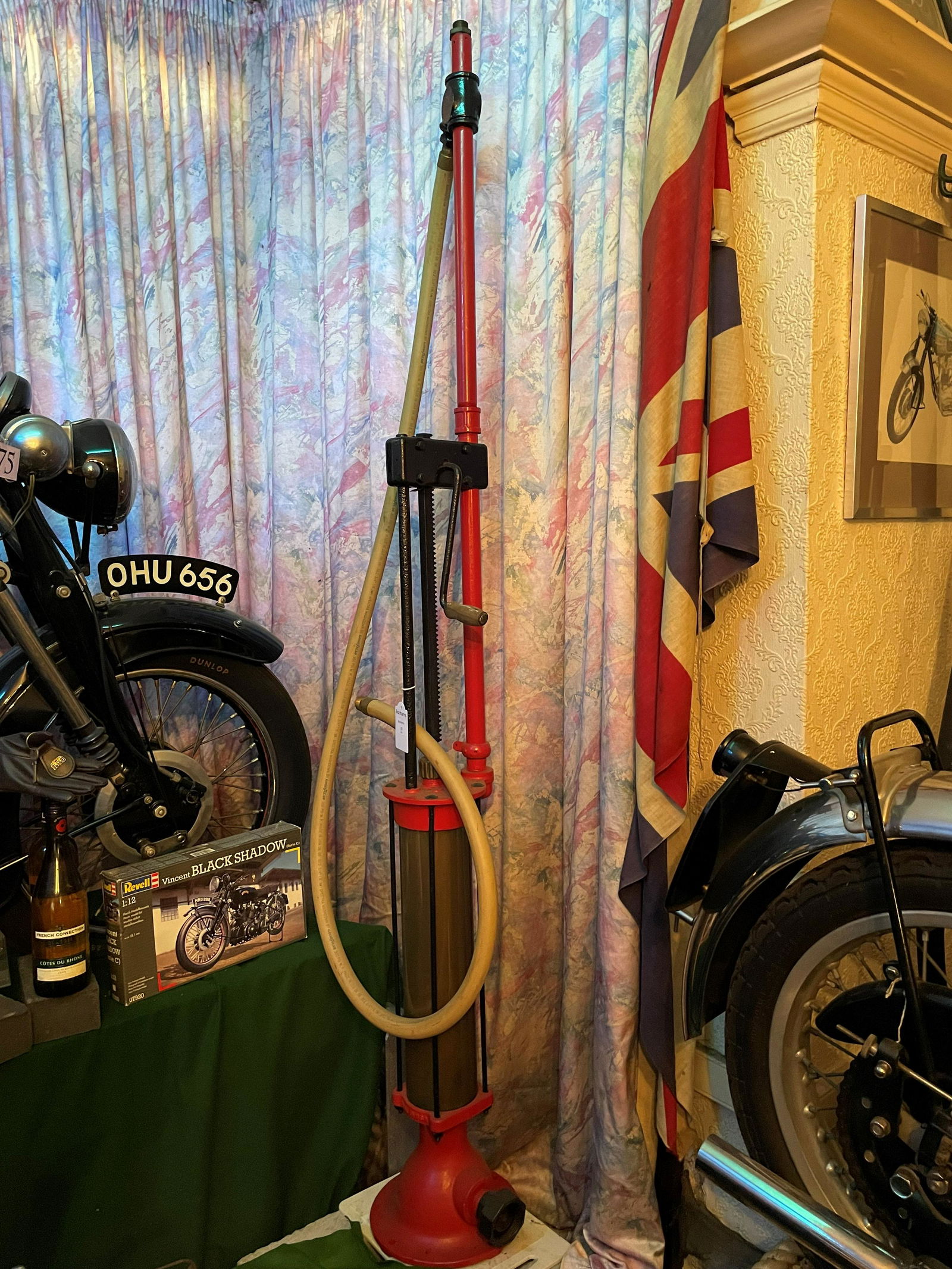 A HAND-CRANKED SKELETON PETROL PUMP: A hand-cranked skeleton petrol pump, painted red, no maker's marks, rubber hose (replaced), and bronze nozzle, 202cm high. This lot is subject to the following lot symbols: ◊◊◊ χ