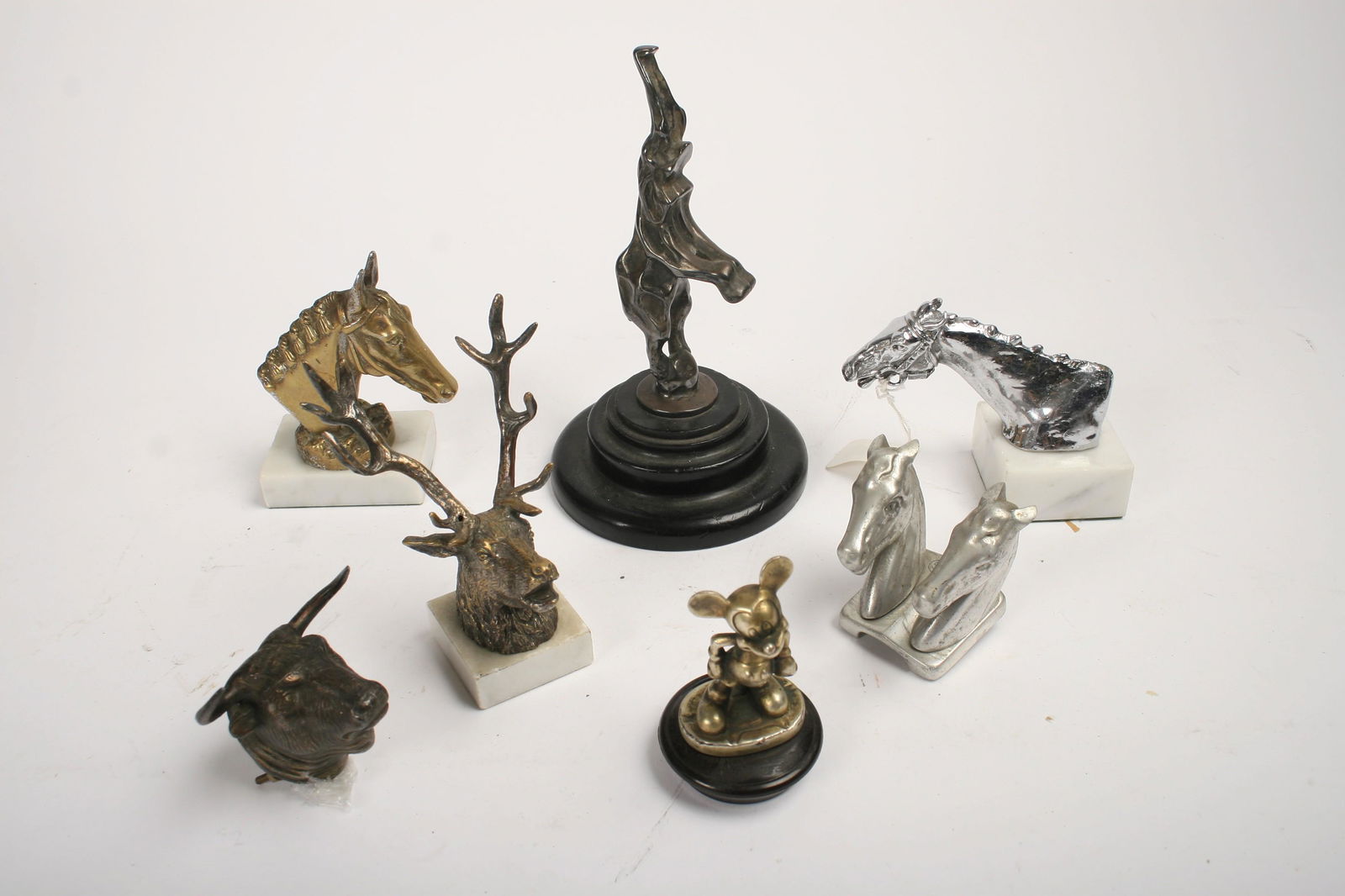 SEVEN ANIMAL MASCOTS: Seven Animal mascots, comprising replica Bugatti Royale Elephant after Rembrandt Bugatti, 16.5cm high, on turned display base, a Stag's Head, on marble base, a Bull's Head, a Thoroughbred Racehorse, B