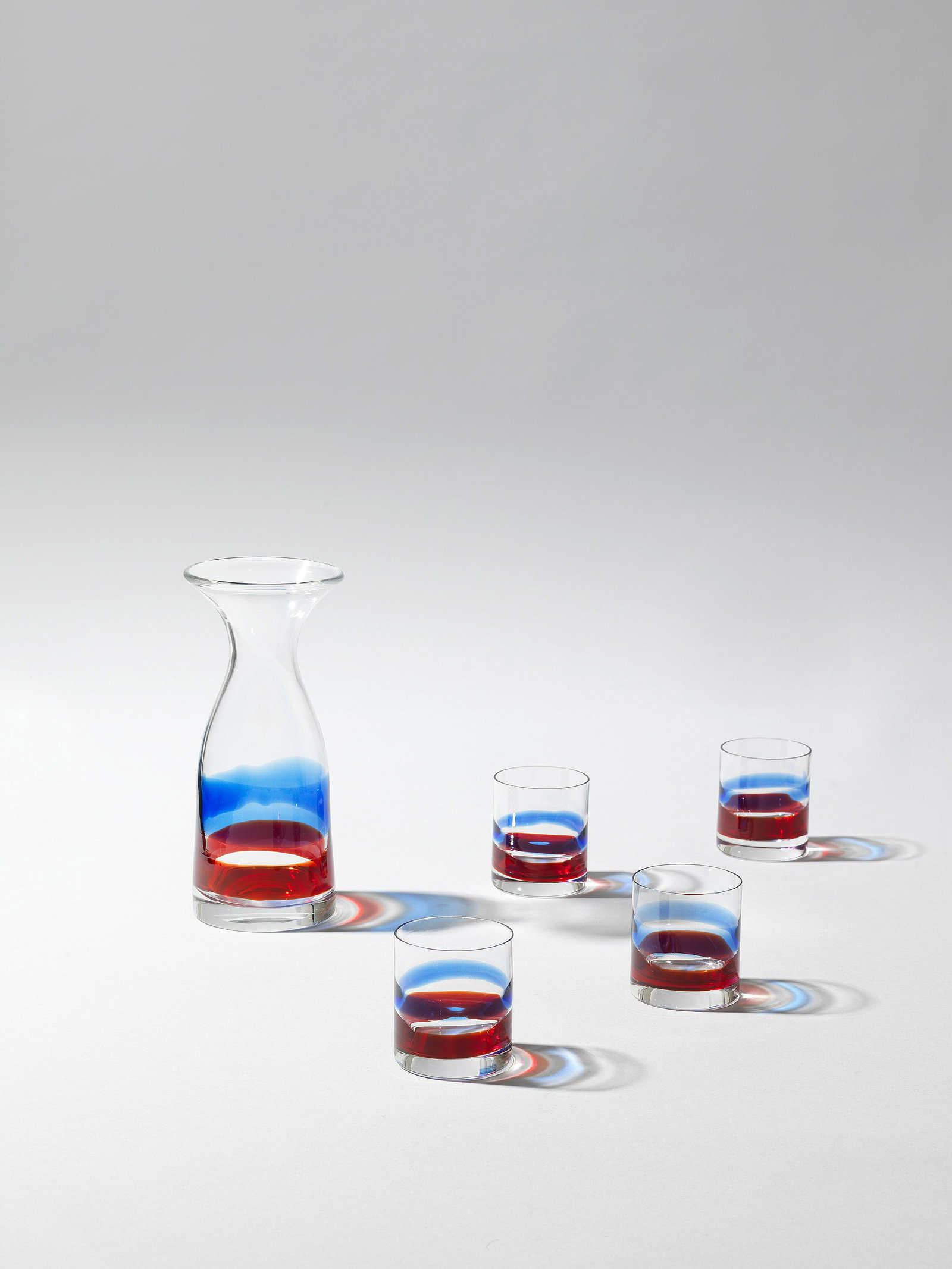 GIO PONTI: Gio Ponti Rare carafe and four glasses from the table service set, no. 970, designed for A.P.E.M., 1946 Clear and coloured glass. Carafe: 24 cm high Each glass: 8 cm high Produced by Venini & C., Mura