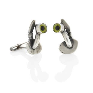 A PAIR OF SILVER AND GLASS EYE CUFFLINKS, SAM KRAMER: A PAIR OF SILVER AND GLASS EYE CUFFLINKS, SAM KRAMEROf abstract design, each with a bezel-set yellow/green taxidermy glass eye; mounted in sterling silver; length 1 3/8 in.; with partial maker's