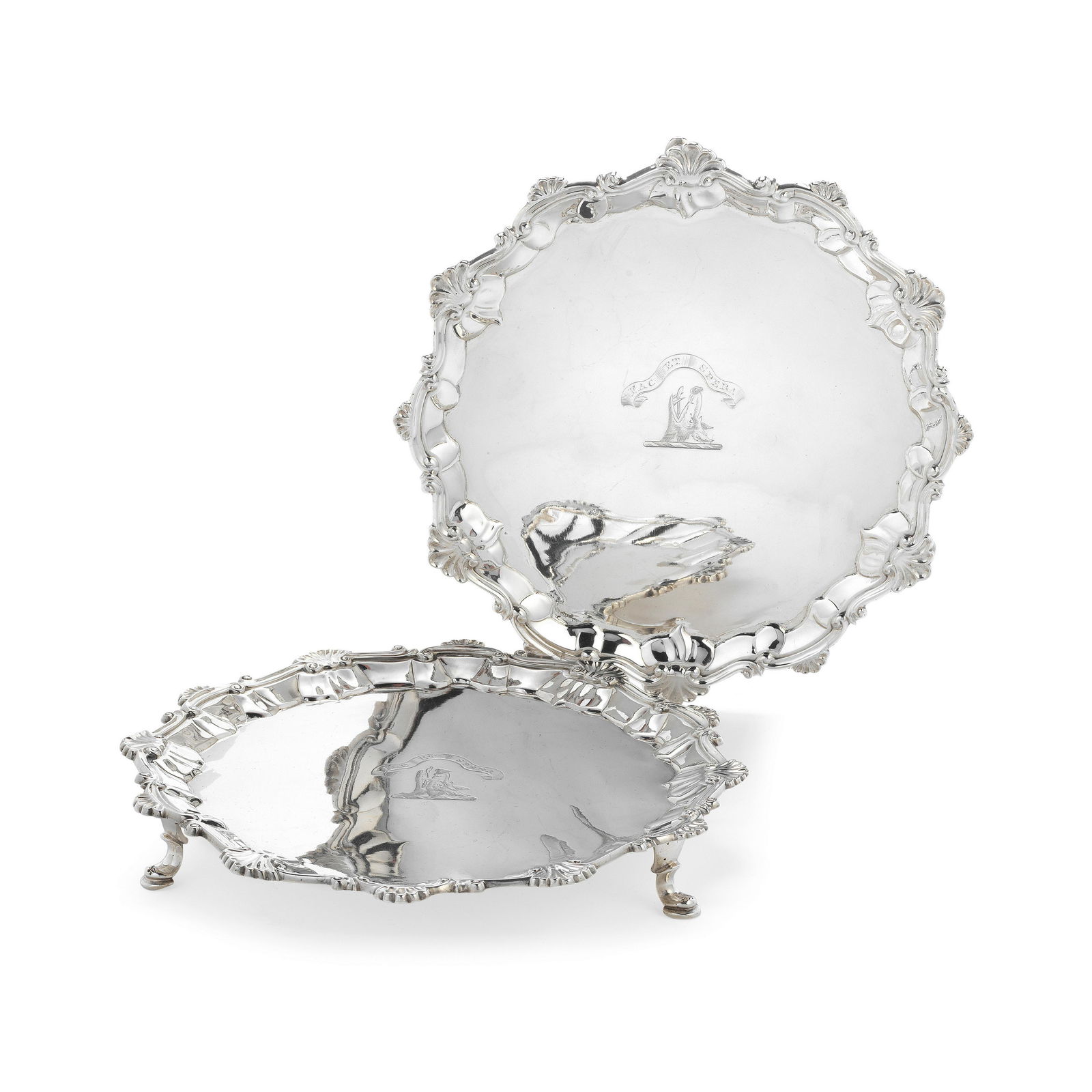A George III matched pair of silver salvers possibly Robert Piercy, London 1762 and John Hannam ...: A George III matched pair of silver salvers possibly Robert Piercy, London 1762 and John Hannam & John Crouch or John Carter, 1765 Shaped-circular with shell and scroll border, later crested to the ce