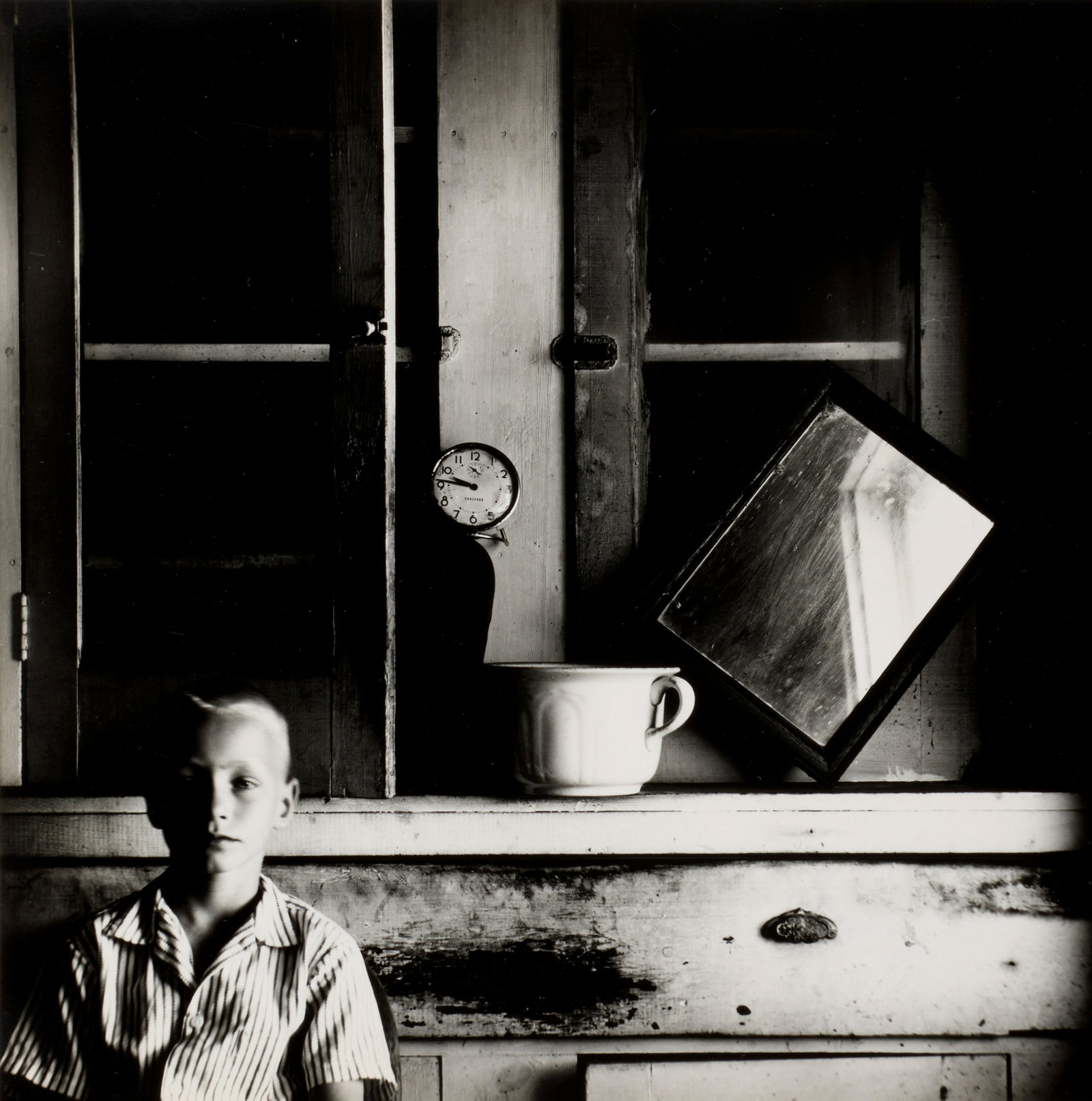 Ralph Eugene Meatyard (1925-1972); Untitled (Boy with clock and mirror);: Ralph Eugene Meatyard (1925-1972) Untitled (Boy with clock and mirror), 1960s Gelatin silver print, printed 1960s, signed by Madelyn O. Meatyard, Estate Executor, in ink on the verso. 7 1/2 x 7 1/4in