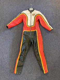 A set of 'Champion Clothing' racing leathers believed to be used in the 1980's 'Silver Dream Rac...: A set of 'Champion Clothing' racing leathers believed to be used in the 1980's 'Silver Dream Racer' filmin heron Suzuki racing colours, Rivetts London patch to front chest, with slight wear and