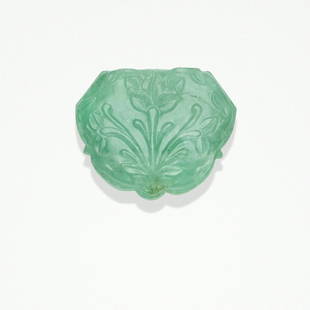 Carved Emerald Plaque: Carved Emerald PlaqueDesigned in the Mughal style, this pastel green carved emerald plaque of shaped outline displays floral and foliate carving to the face and incised geometric lines depicting a