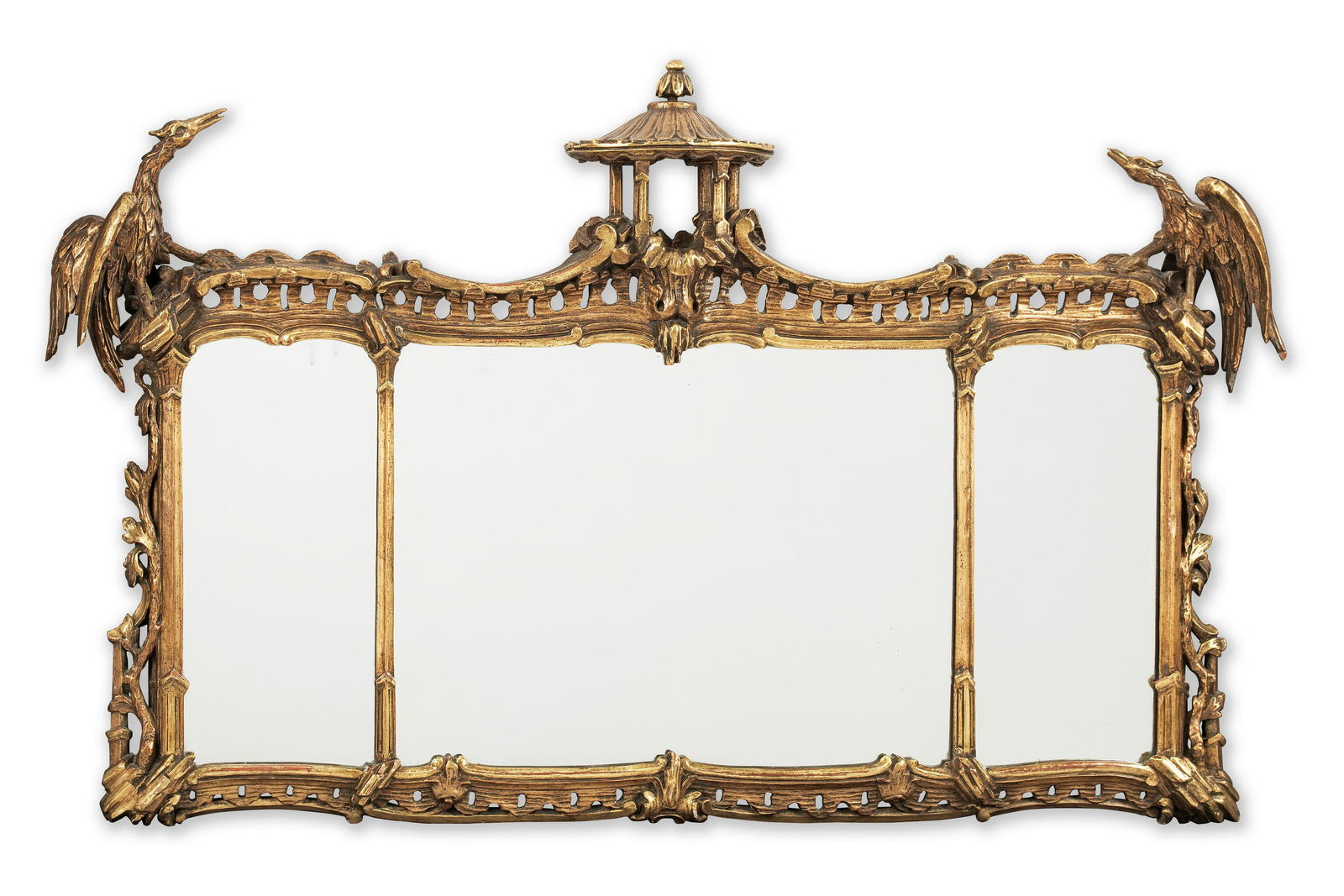 A GEORGE II STYLE CARVED GILTWOOD TRIPLE OVERMANTEL MIRRORIn the style of Thomas Chippendale: A GEORGE II STYLE CARVED GILTWOOD TRIPLE OVERMANTEL MIRROR In the style of Thomas Chippendale The split rectangular plate surmounted by a Pagoda flanked by ho ho birds, 149cm wide (59in wide) This lot
