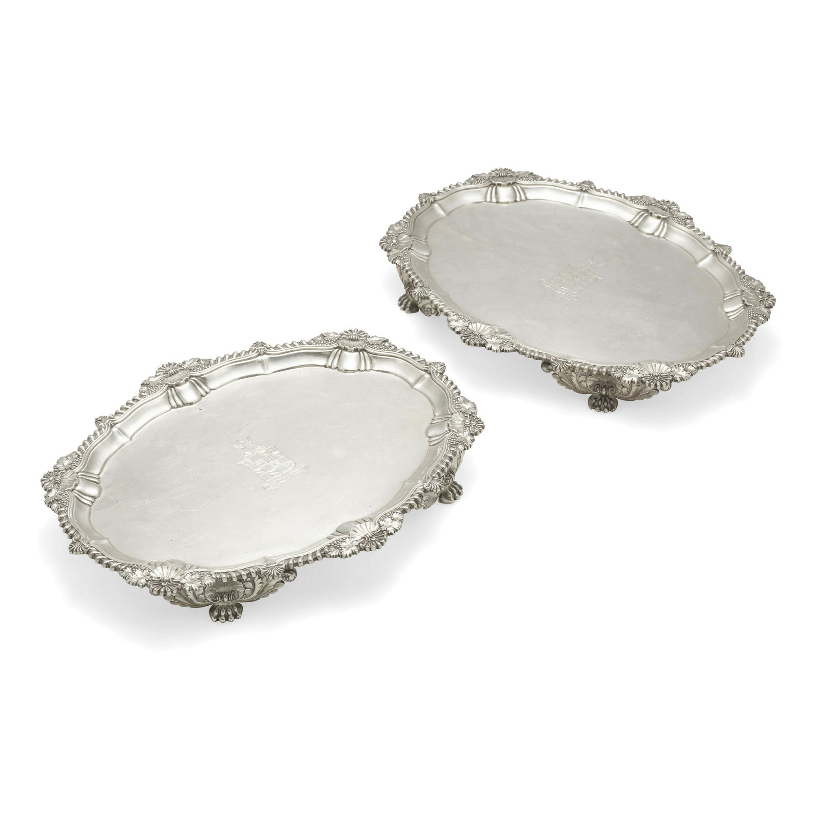 A PAIR OF REGENCY SILVER FOOTED SALVERS by Benjamin Smith II & James Smith III, London, 1812: A PAIR OF REGENCY SILVER FOOTED SALVERS by Benjamin Smith II & James Smith III, London, 1812 With applied rocaille edges and engraved crest to center; length 13 1/4in (33.5cm); width 10 3/4in (27.4cm)