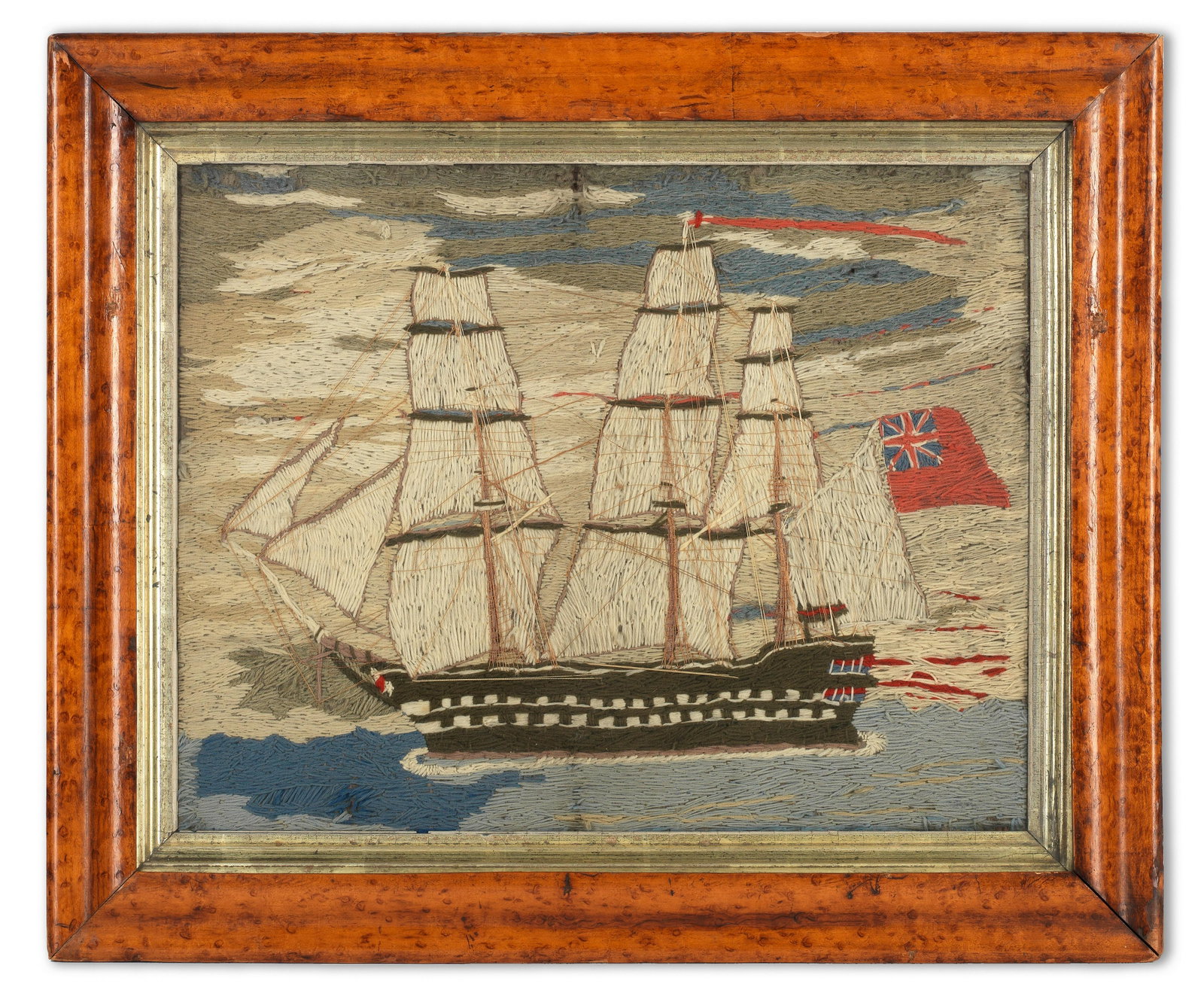 A British sailer's woolwork 'Woolie' of a merchant navy frigate 19th century: A British sailer's woolwork 'Woolie' of a merchant navy frigate 19th century Embroidered in blues, whites, and tans, the vessel depicted from a side view in full sail flying the Red Ensign, glazed wit