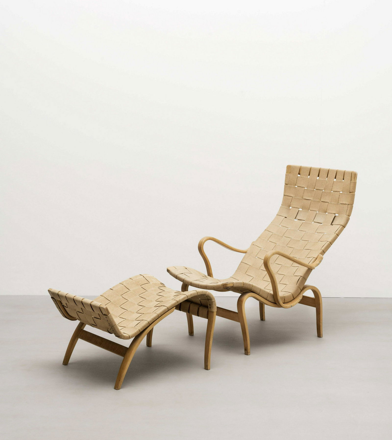 Bruno Mathsson 'Pernilla 1' easy chair and foot stool, designed 1943: Bruno Mathsson 'Pernilla 1' easy chair and foot stool, designed 1943 Beech, canvas. Chair: 91.5 x 64 x 99.5 cm Foot stool: 40.5 x 51 cm Produced by Firma Karl Mathsson, Sweden and retailed by Illums B