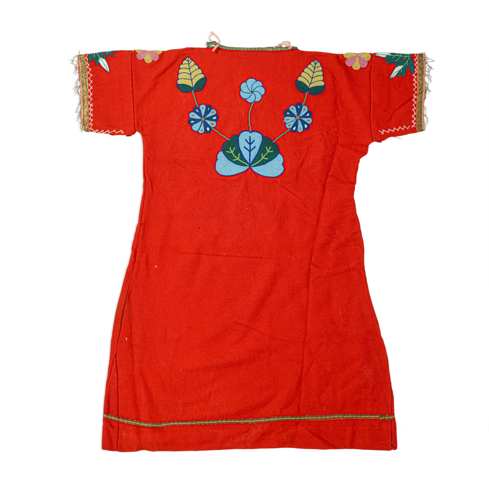 An Apsáalooke (Crow) beaded dress: An Apsáalooke (Crow) beaded dress The upper portion designed with vining floral and foliate designs front and back on red felt, with ribbon borders on the sleeves and above the hem. laid flat: le