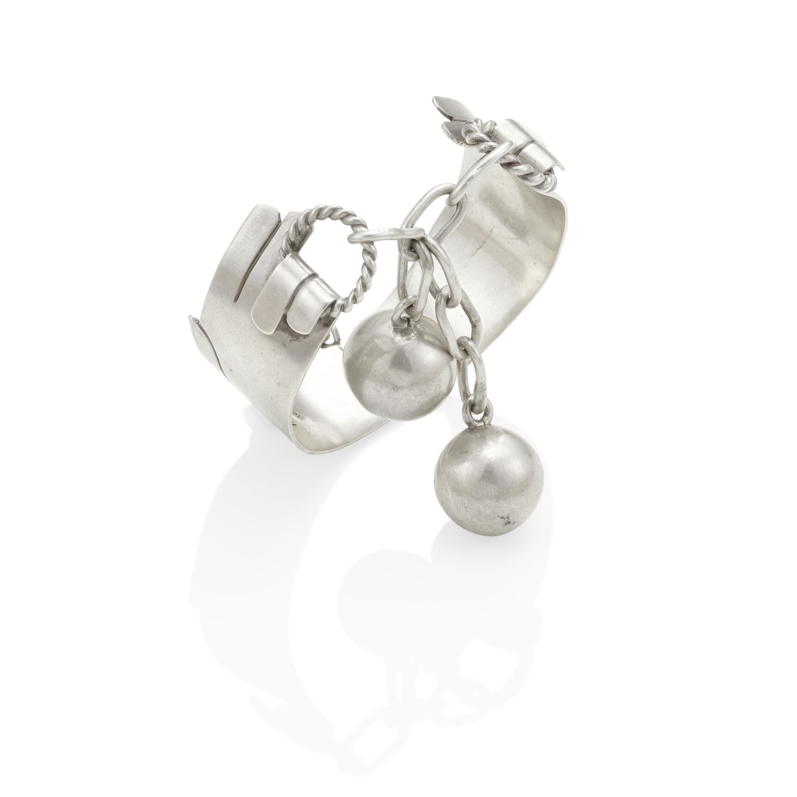 HUBERT HARMON: A SILVER BRACELET, MEXICO: HUBERT HARMON: A SILVER BRACELET, MEXICO Designed as two hands holding twisted wire rings linked together by a chain suspending two silver balls, eagle 1 stamp, inner circumference 7 1/4 in.