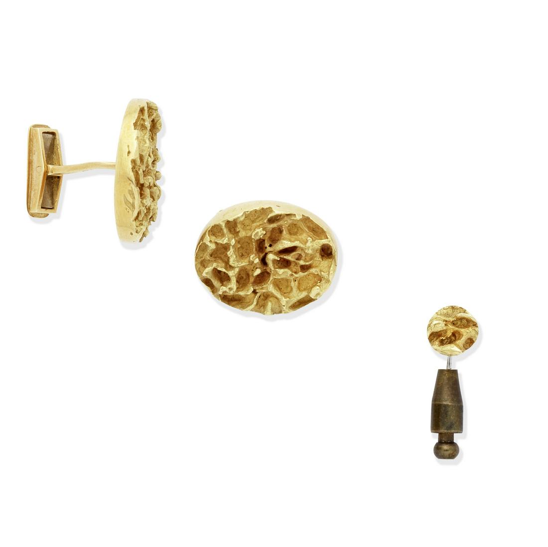 GRIMA: GOLD CUFFLINKS AND LAPEL PIN: GRIMA: GOLD CUFFLINKS AND LAPEL PIN Single-sided, each 18 carat gold oval plaque of textured finish, the pin of matching design, signed Grima, London hallmark, length of plaque 2.4cm