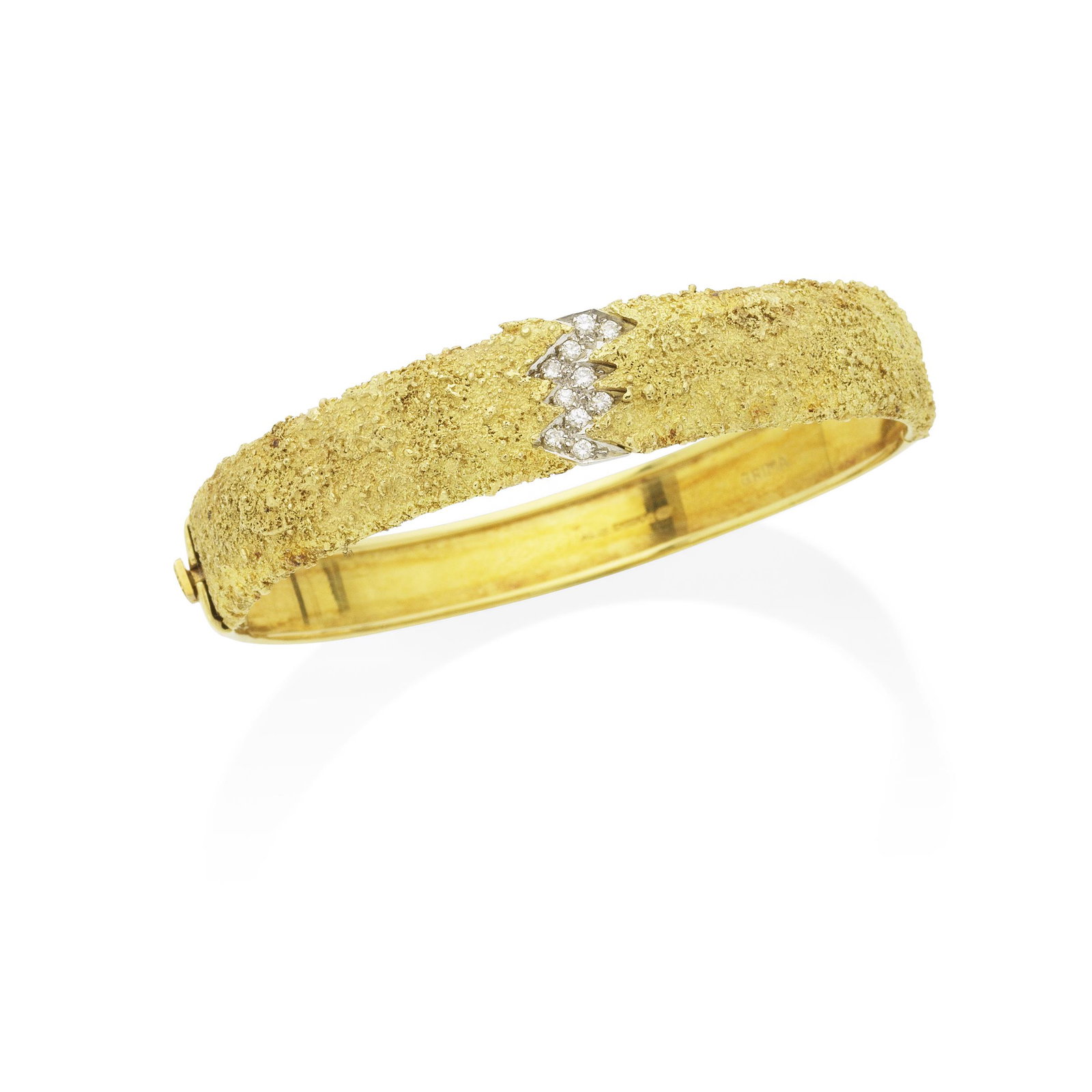 GRIMA: DIAMOND-SET GOLD BANGLE, 1986: GRIMA: DIAMOND-SET GOLD BANGLE, 1986 The centre pavé-set with a zig-zag motif of brilliant-cut diamonds, between textured shoulders in 18 carat gold, signed Grima and AGLtd, London hallmark, Eur