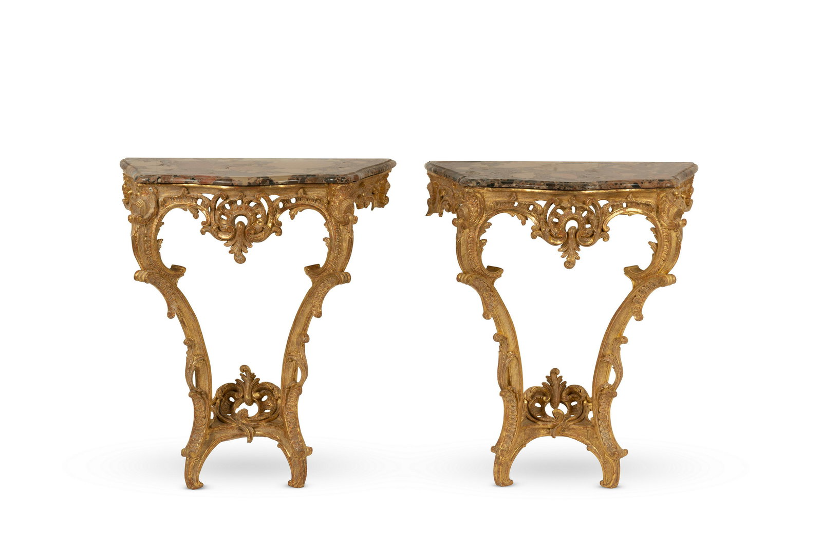 A fine pair of small Louis XV carved giltwood console tables (2): A fine pair of small Louis XV carved giltwood console tables With later serpentine shaped bréche d'Alep marble tops above a pierced scrolling apron on double C-scroll legs united by a shaped stre
