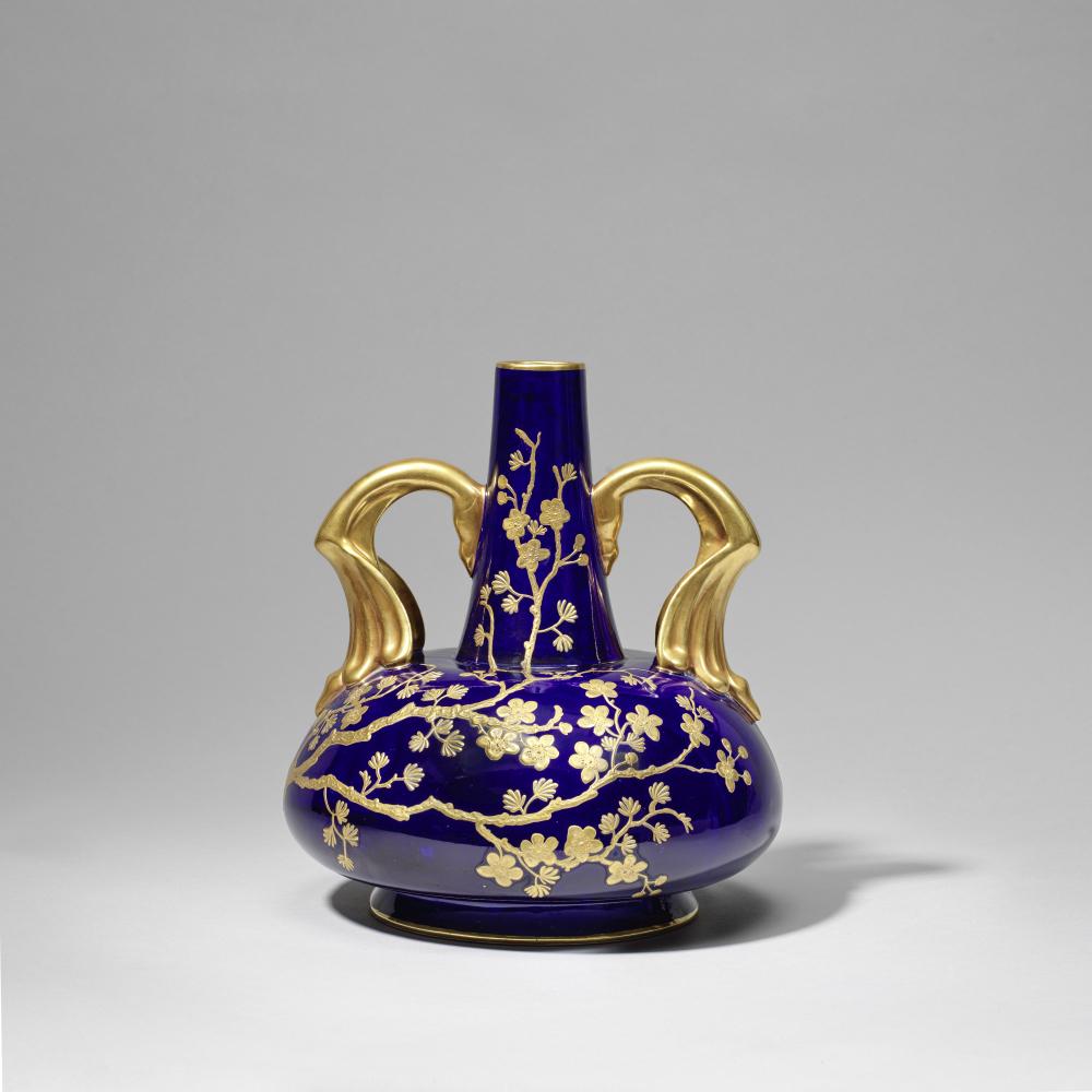 Attributed to Dr Christopher Dresser: Made by Old Hall Vase with elaborate handles, circa 1885: Attributed to Dr Christopher Dresser: Made by Old Hall Vase with elaborate handles, circa 1885 Earthenware, with elaborate gilded handles and raised decoration of trailing prunus blossom. 25 cm high P