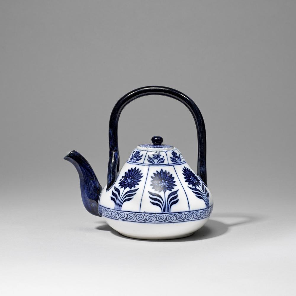 Dr Christopher Dresser: Made by Minton Aesthetic Movement teapot with cover, 1879: Dr Christopher Dresser: Made by Minton Aesthetic Movement teapot with cover, 1879 Decorated underglaze in blue and white with stylised flowers, with overhead handle. 18.5 cm high Impressed 'Minton' wi