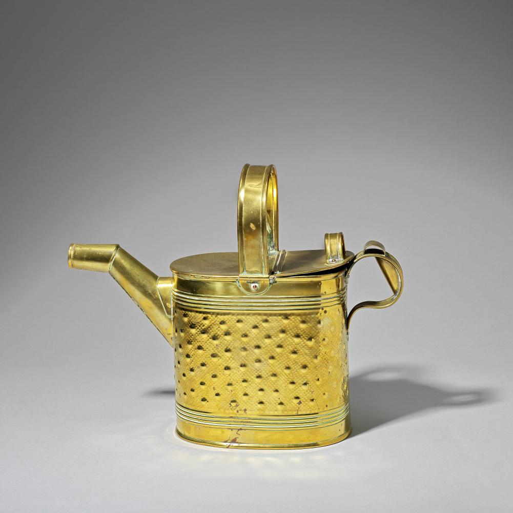 R. Perry & Sons: After a design by Dr Christopher Dresser Watering can, circa 1890Brass, with an...: R. Perry & Sons: After a design by Dr Christopher Dresser Watering can, circa 1890 Brass, with angled spout, overhead and side handles, hinged lid at the back, embossed decoration. 27.4 cm high Stampe