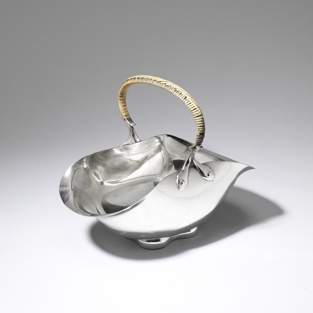 After Dr Christopher Dresser: Made by Hukin & Heath Bowl with handle, no. 2960, circa 1890: After Dr Christopher Dresser: Made by Hukin & Heath Bowl with handle, no. 2960, circa 1890 Electroplated, the large bowl with squashed sides and central wicker-covered handle. 21.5 cm high, 28.1 cm wi