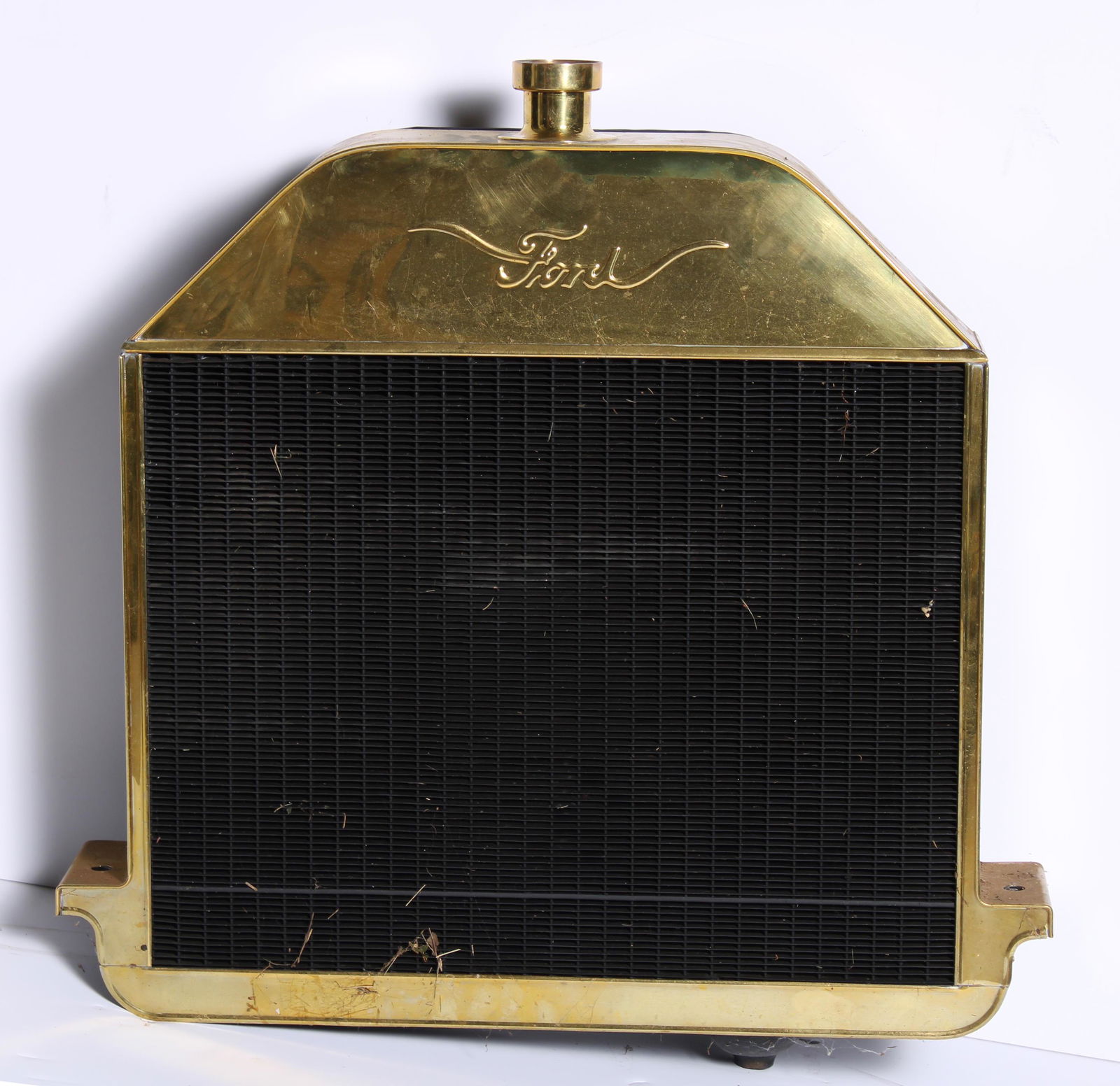A replica 1909-10 Ford Model T radiator,: A replica 1909-10 Ford Model T radiator, modern, polished brass surround, 20 inches wide with mounting brackets, 23 inches wide overall. Lot to be sold without reserve. Buyer's Premium Notice:For AUTO