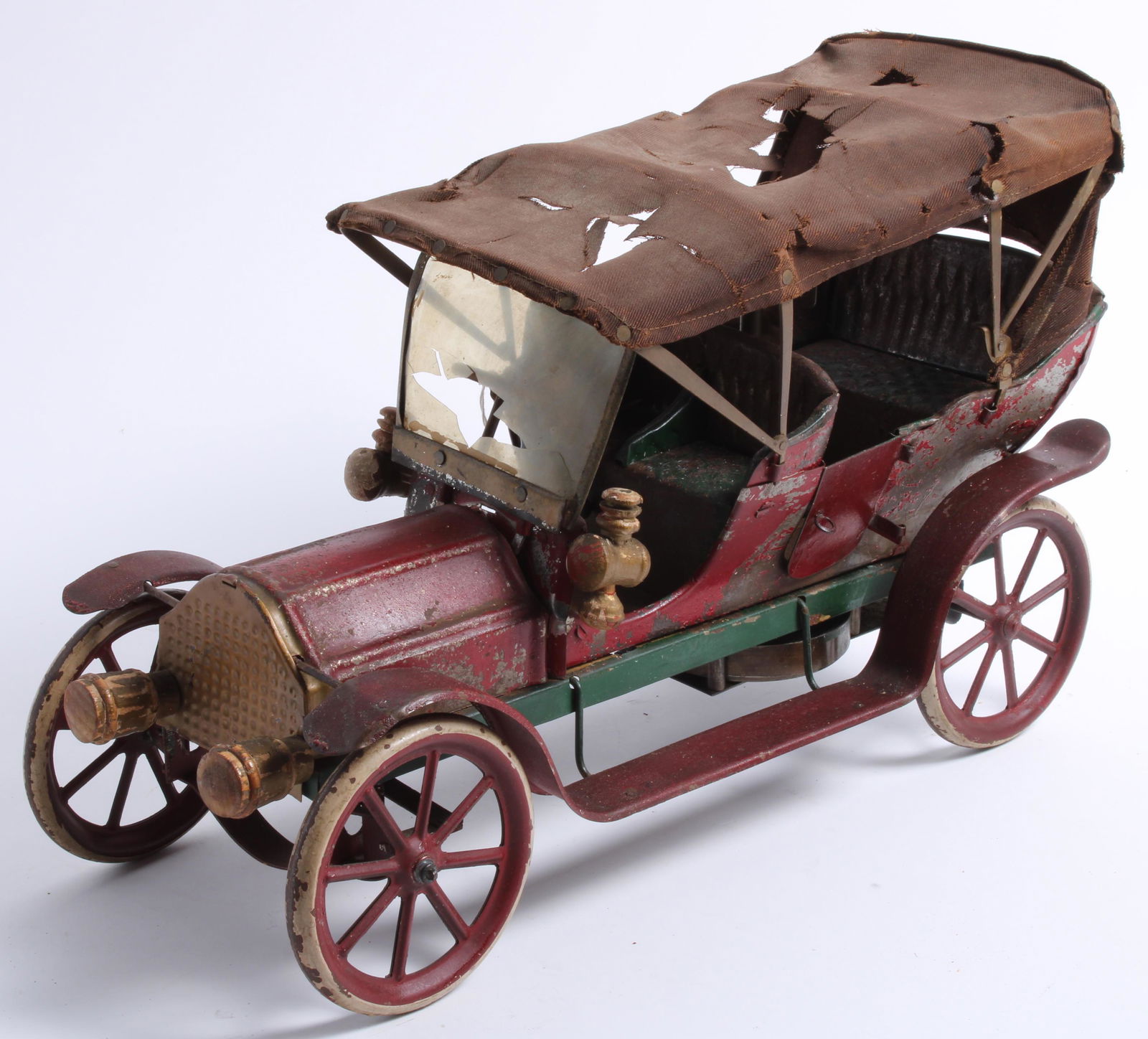 A large Morton Converse clockwork tinplate touring car, American, circa 1910,: A large Morton Converse clockwork tinplate touring car, American, circa 1910, painted in red and gold, with remains of celluloid windscreen and canvas hood (both distressed), painted wooden lights, 15