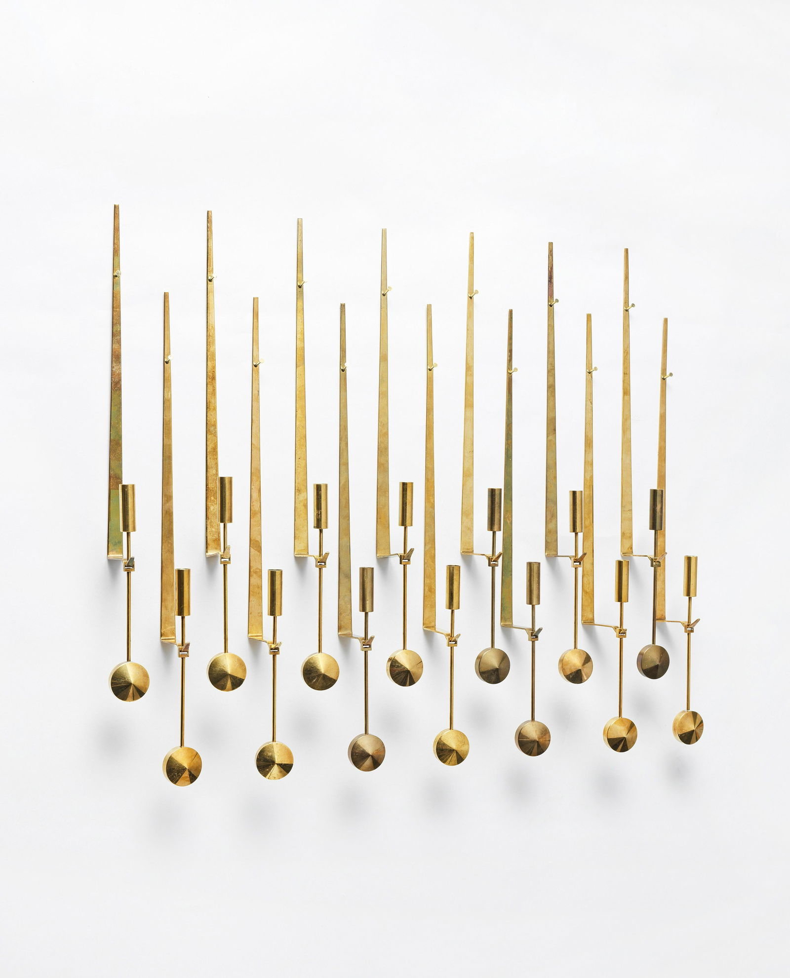 Pierre Forssell Group of 14 'Pendel' wall-mounted candle holders, designed late 1950s: Pierre Forssell Group of 14 'Pendel' wall-mounted candle holders, designed late 1950s Brass. Each: 47.5 x 4 x 8 cm Manufactured by Skultuna 1607, Sweden. Each impressed with manufacturer's mark Skultu