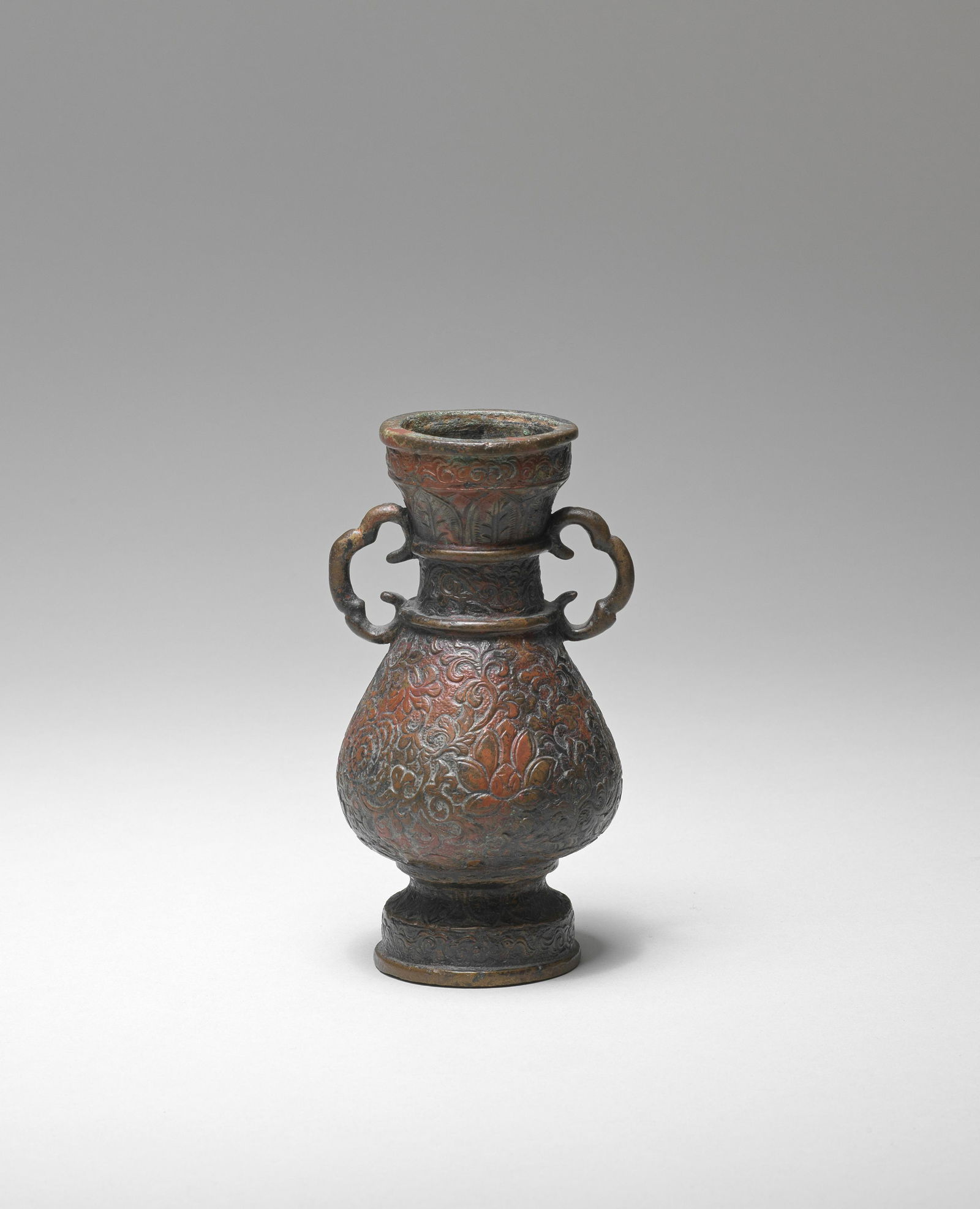 A CLOUD-HANDLED BRONZE VASE, HU Ming Dynasty: A CLOUD-HANDLED BRONZE VASE, HU Ming Dynasty Heavily cast of elegant pear shape, rising from a stepped foot to a narrow waisted neck and galleried rim, the shoulders set with a pair of ruyi cloud-shap