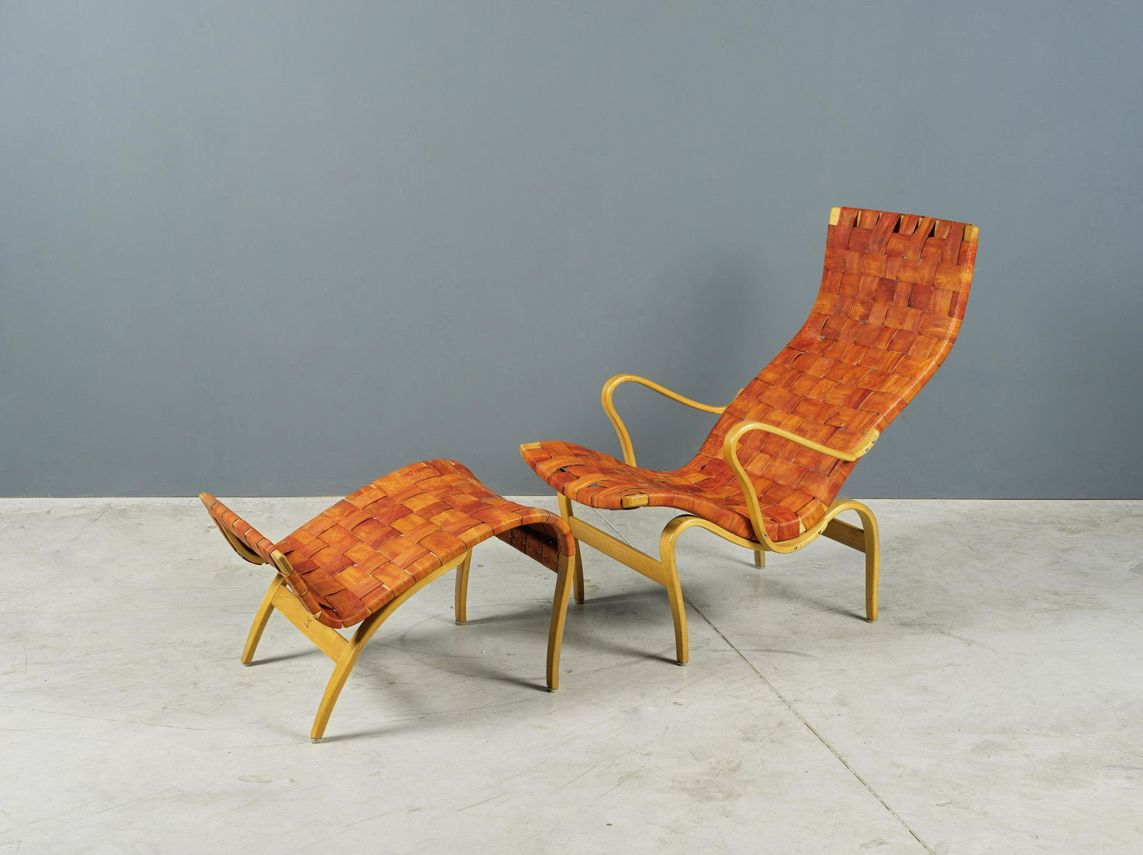 BRUNO MATHSSON (1907-1988) Fauteuil et ottoman 'Pernilla'Création en 1943Estampillé, e...: BRUNO MATHSSON (1907-1988) Fauteuil et ottoman 'Pernilla' Création en 1943 Estampillé, edition Firma Karl Mathsson, en bois de hêtre et cuir Fauteuil: H: 93cm.(36 5/8in.); L: 64cm.(25 3