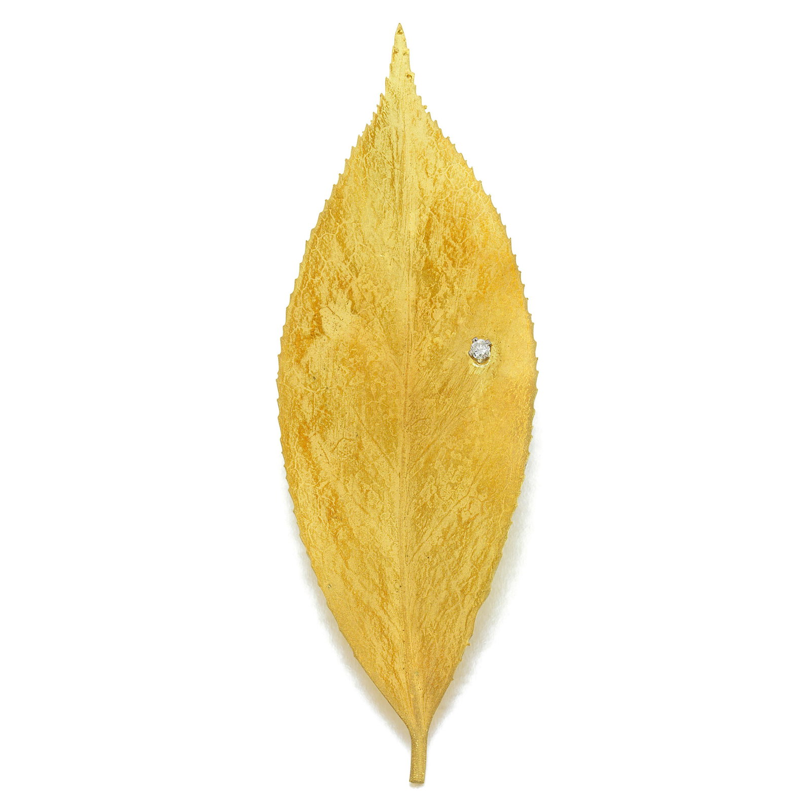 GRIMA: AN 18K GOLD AND DIAMOND FOLIATE BROOCH, CIRCA 1986: GRIMA: AN 18K GOLD AND DIAMOND FOLIATE BROOCH, CIRCA 1986 Designed as a textured leaf accented by a round diamond to resemble a dew drop; signed Grima; measures 3¾ x 1¼ in. Footnotes: Cf. E