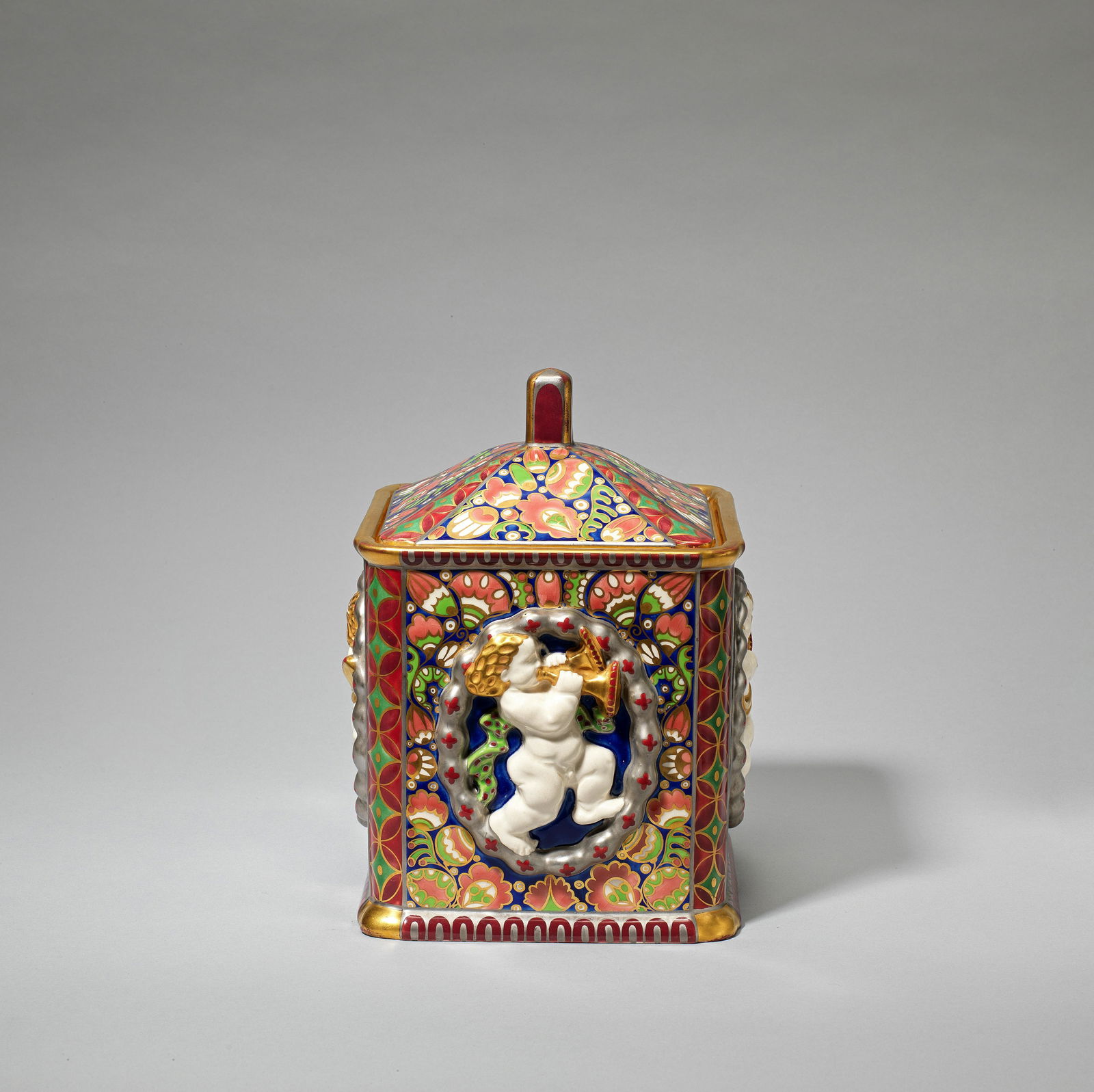Franz Staudigl and Karl Klaus for Ernst Wahliss 'Serapis' biscuit box and cover, model no. 10001...: Franz Staudigl and Karl Klaus for Ernst Wahliss'Serapis' biscuit box and cover, model no. 10001, circa 1911Earthenware, decorated in relief with figural ovals with putti playing trumpets and horns, fu