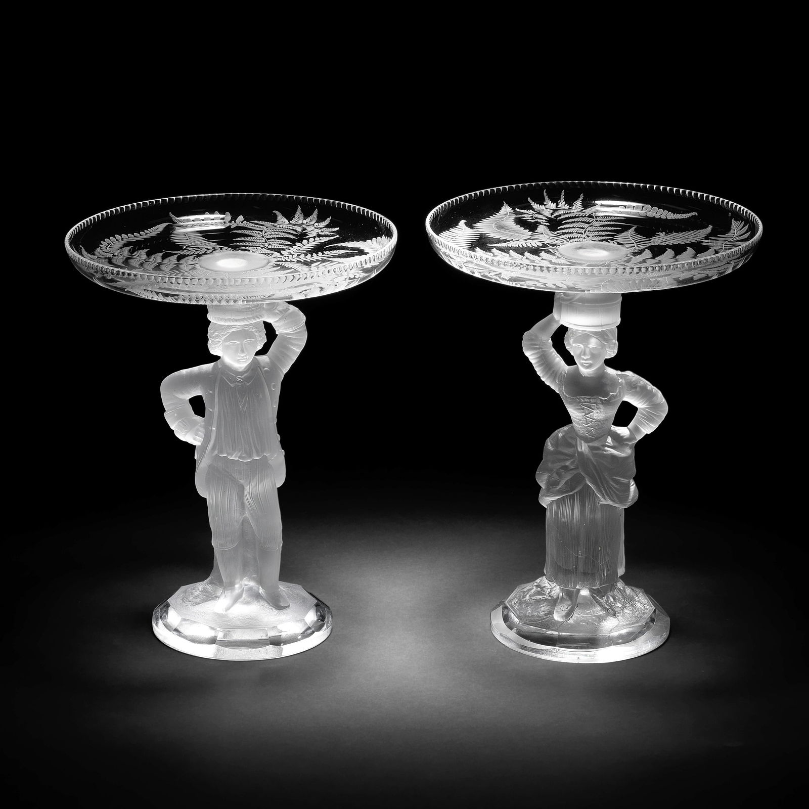 A pair of figural tazzas by John Ford and Co, Holyrood Glassworks, Edinburgh, circa 1870: A pair of figural tazzas by John Ford and Co, Holyrood Glassworks, Edinburgh, circa 1870Modelled as a fisher boy and fisher girl in frosted glass standing with one hand on their hips, he with his left