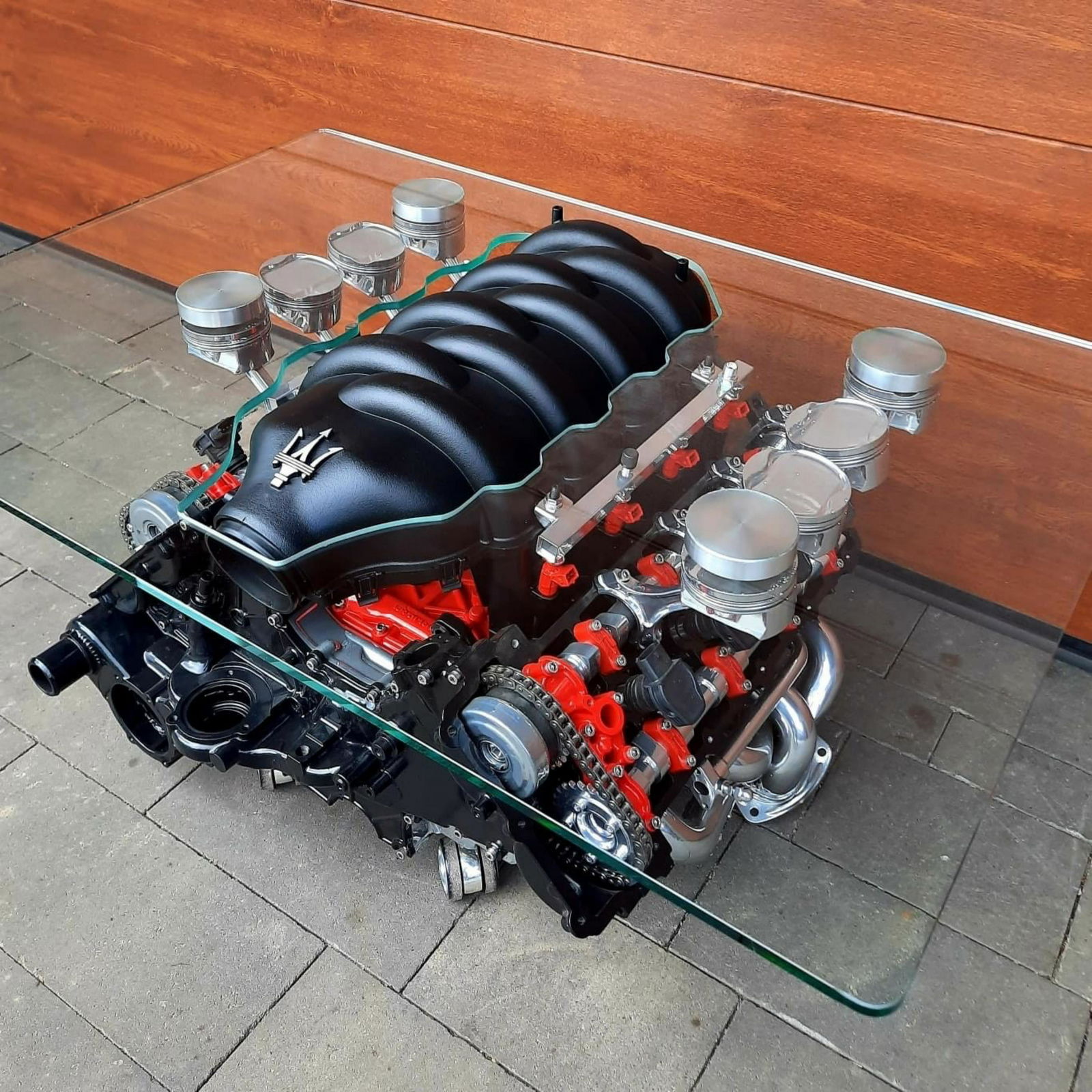 A Maserati Quattroporte 4.2 V8 engine coffee table,: A Maserati Quattroporte 4.2 V8 engine coffee table, the 2005 engine reconditioned, sonically cleaned and presented as a unique coffee table with 8mm thick tempered glass custom-cut table top, mounted