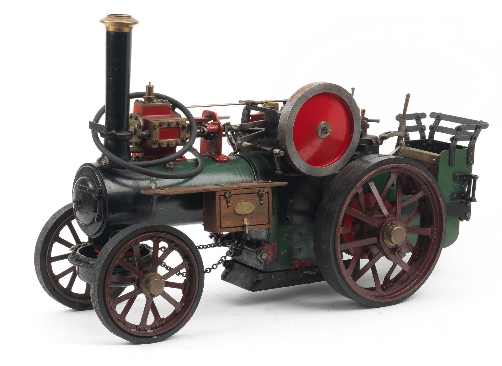 A live steam engineer's model of a General Purpose Traction Engine,: A live steam engineer's model of a General Purpose Traction Engine, maker unknown, possibly by Bassett-Lowke, predominantly green, red and black, with maroon spoked solid rubber tyres, 67cm long. This