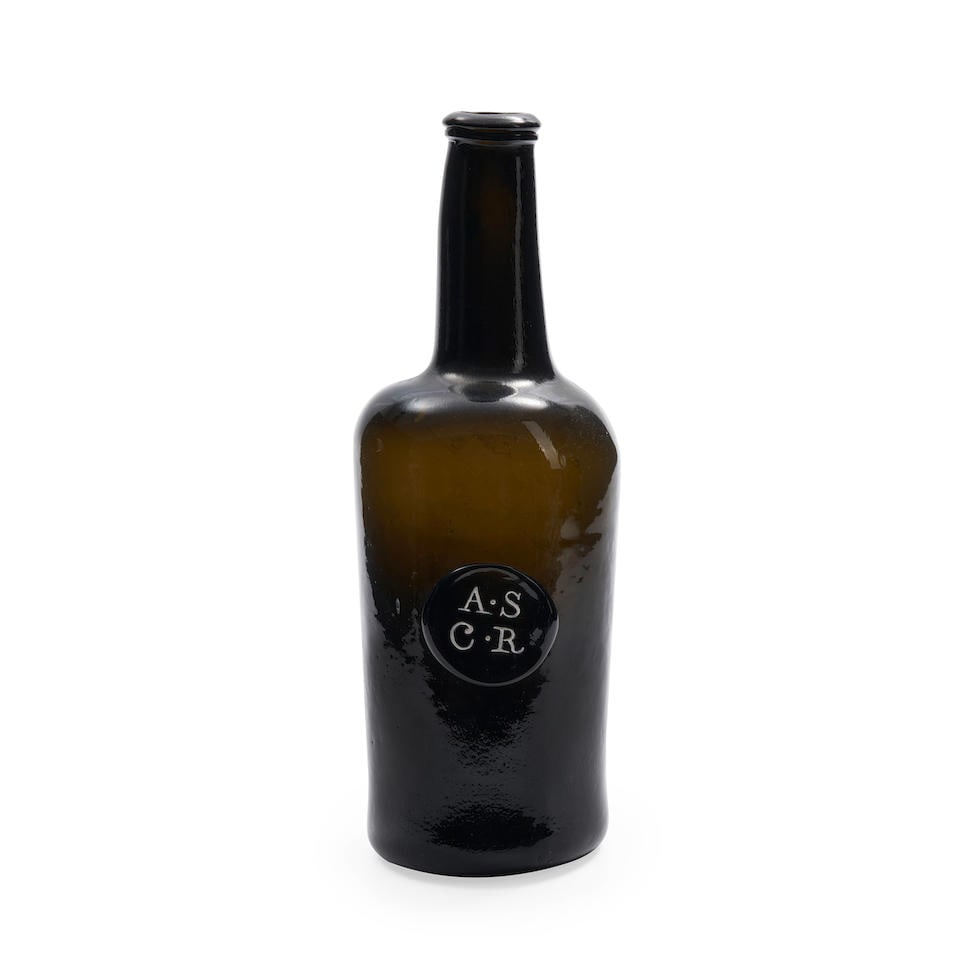 A Sealed 'Cylinder' Wine Bottle, circa 1770-80,: A Sealed 'Cylinder' Wine Bottle, circa 1770-80, of dark olive-green tint, the narrow body with a long tapering neck with a string rim, applied to the side with a circular seal molded 'A.S./ C.R' for A