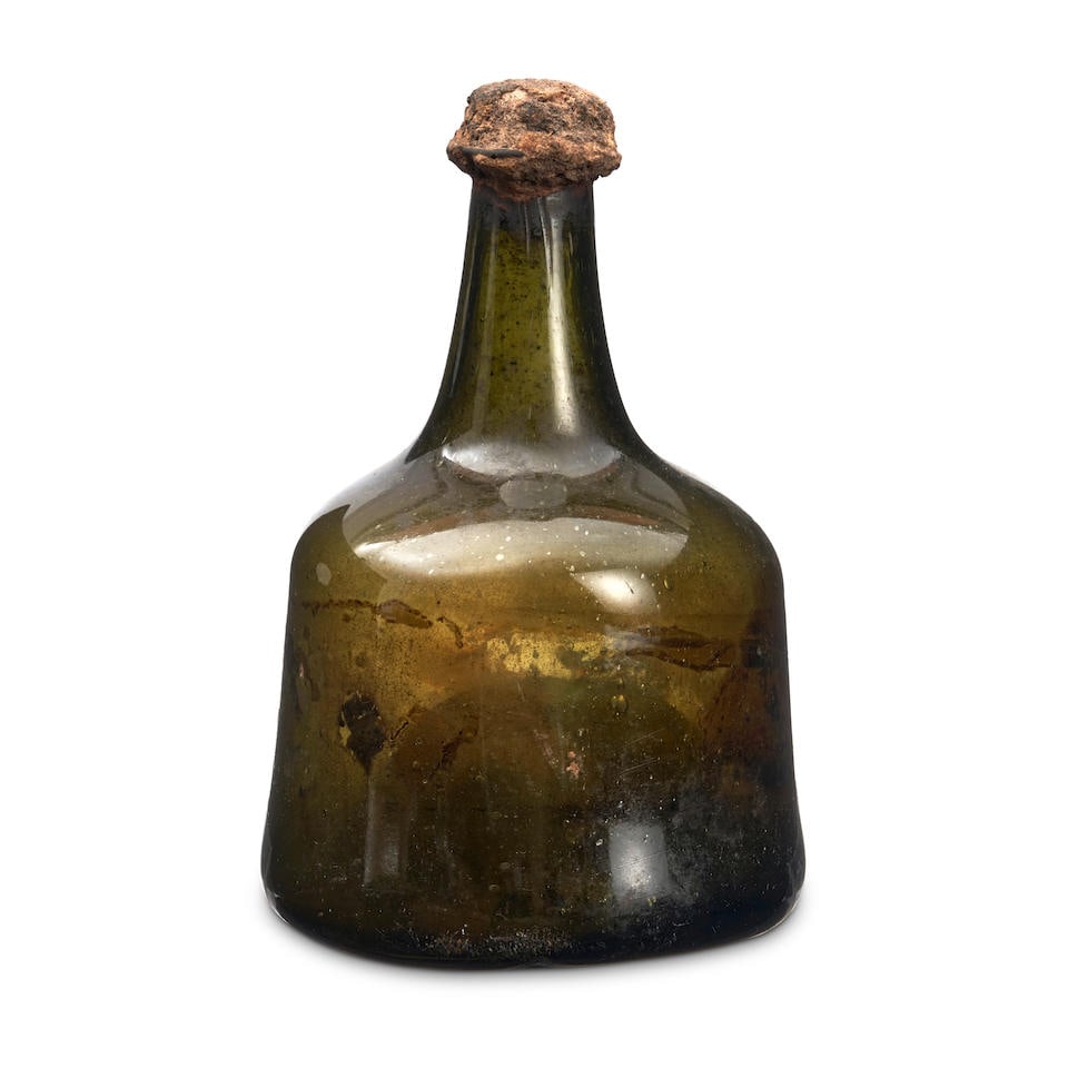 A 'Mallet' Wine Bottle, circa 1730-40,: A 'Mallet' Wine Bottle, circa 1730-40, of olive-green tint, the wide body with a tapering neck and string rim, with a 'kick-up' base, sealed with the original cork, ht. 8 1/4 in. Footnotes: Provenance