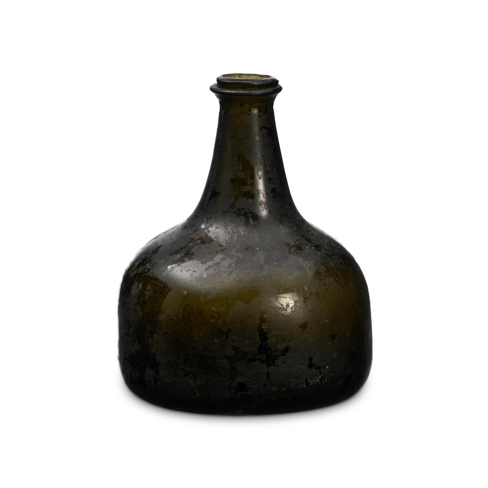 A 'Mallet' Wine Bottle, circa 1725-30,: A 'Mallet' Wine Bottle, circa 1725-30, of olive-green tint, the wide body with a tapering neck applied with a string rim, with a 'kick-up' base, ht. 5 in. Footnotes: Provenance With Neil Willcox, July