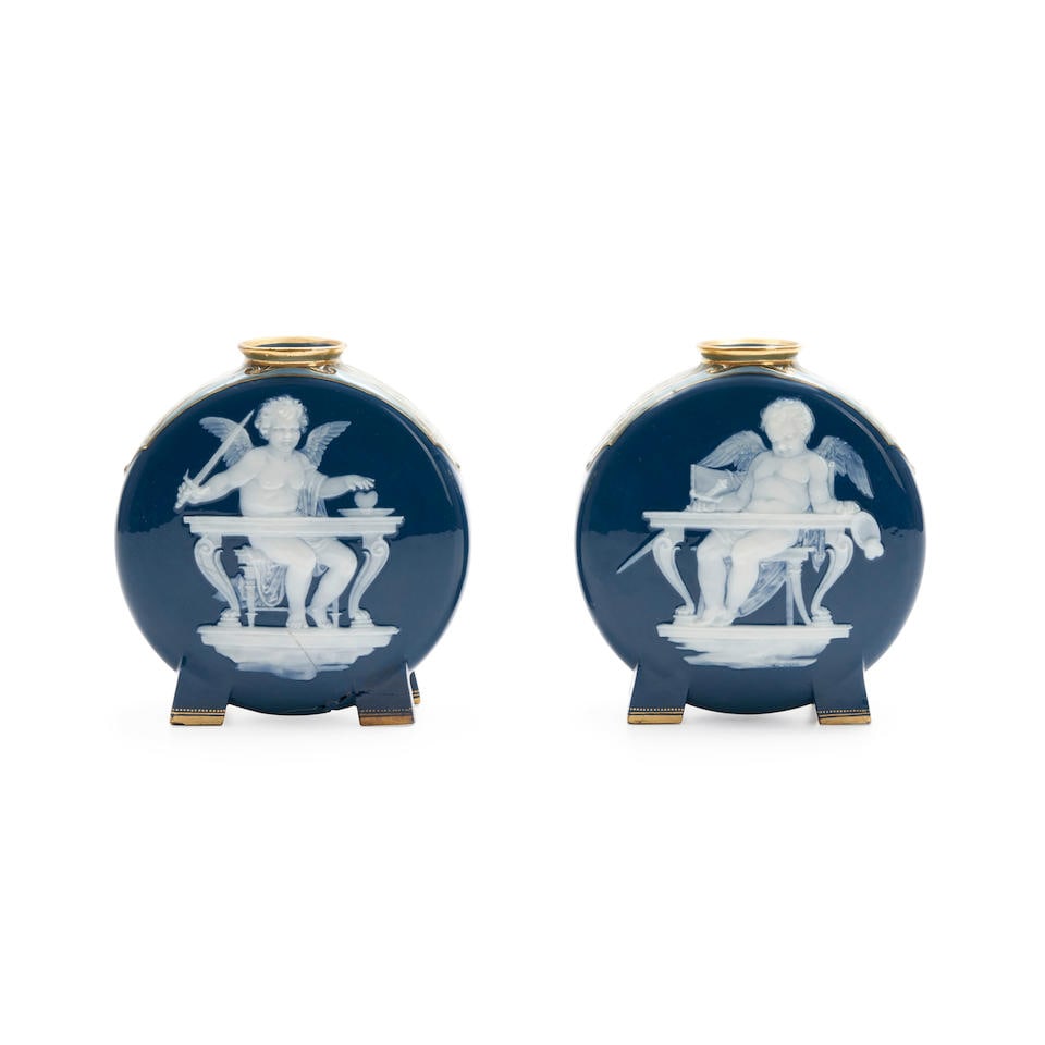 Pair of Mintons Pâte-sur-pâte Marc Louis Solon Decorated Flasks, England, c. 1872,: Pair of Mintons Pâte-sur-pâte Marc Louis Solon Decorated Flasks, England, c. 1872, each with white paste depictions of cupid's seated behind a desk, gilt trim to a blue ground with green sca