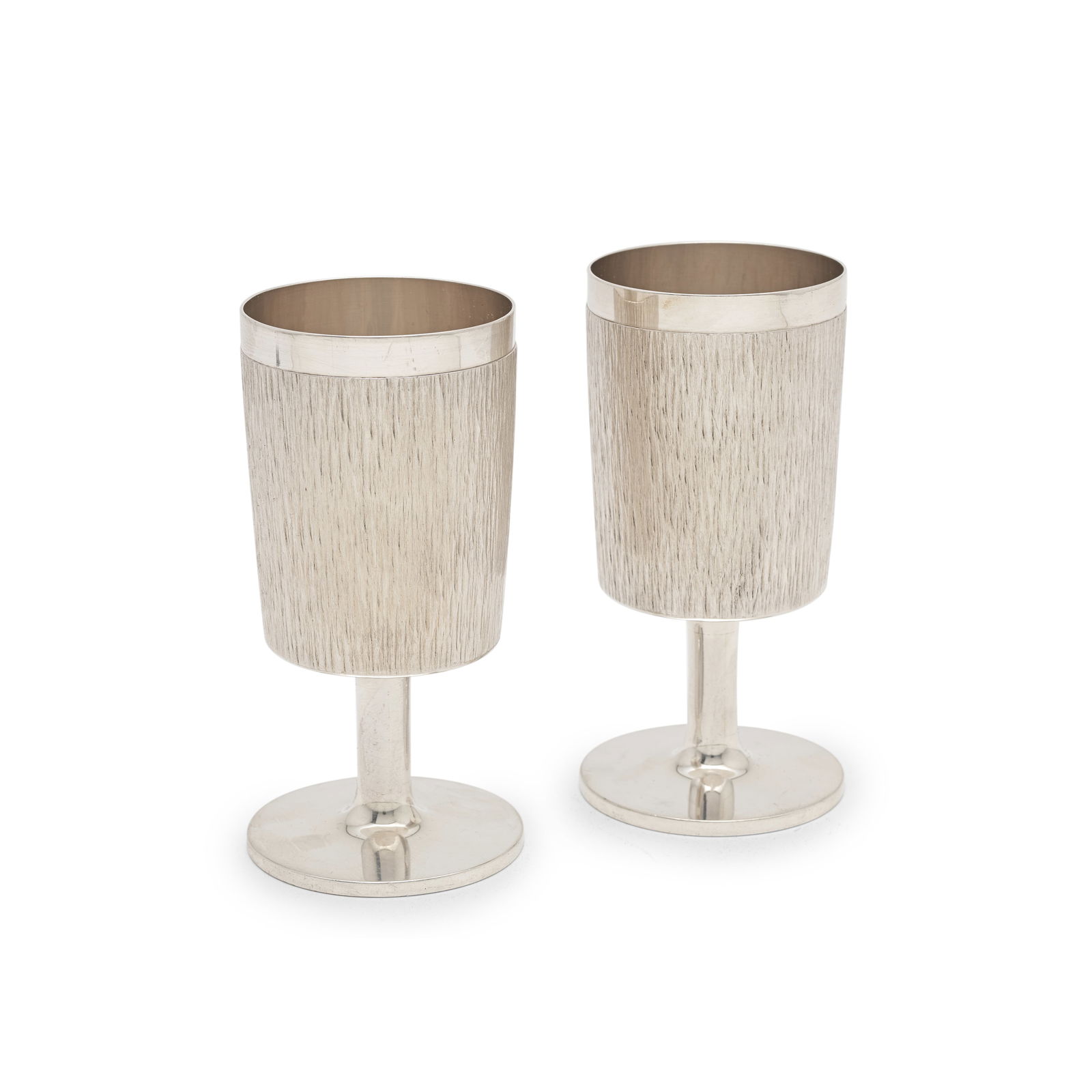 GERALD BENNEY: a pair of silver goblets London 1966 (2): GERALD BENNEY: a pair of silver goblets London 1966 The slightly curved bark effect textured surface below a polished rim, polished stem and circular foot, boxed, height 12.7cm, weight 15.4oz. (2) Thi