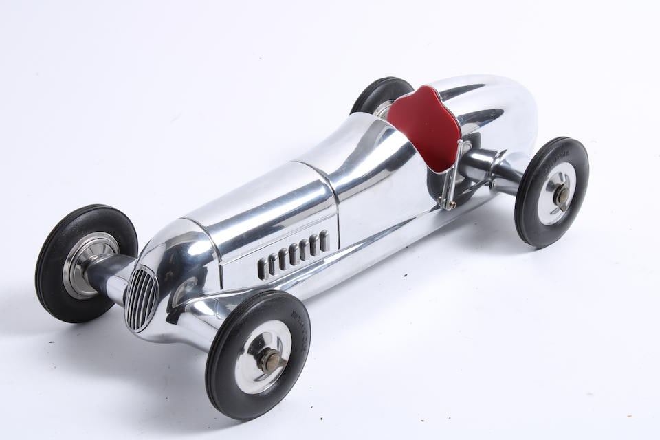 A single seater Indianapolis style racecar: A single seater Indianapolis style racecar Polished alloy body, modern precision construction, with details including Indianapolis marked tyres, steering wheel, handbrake lever and red leatherette sea