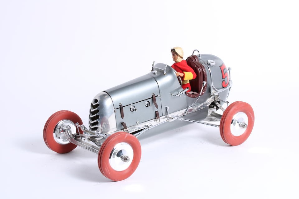 A Model of a midget racecar based upon a replica Bremer Whirlwind tether race car chassis: A Model of a midget racecar based upon a replica Bremer Whirlwind tether race car chassis modern, polished cast alloy and silver painted bodywork, fitted with model Offenhauser engine, action figure '