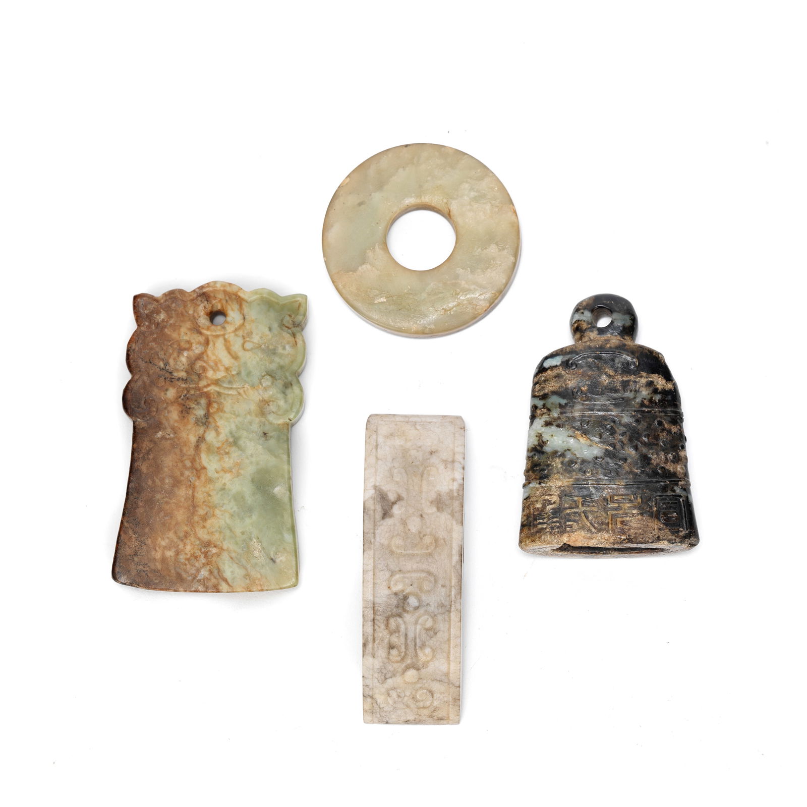 FOUR ARCHAISTIC JADE CARVINGS Early 20th Century (4): FOUR ARCHAISTIC JADE CARVINGS Early 20th Century Comprising: a celadon jade circular bi disc; a sword slide; a 'chicken bone' jade sword slide incised with C-scroll patterns; a celadon and russet jade