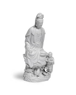 A BLANC-DE-CHINE FIGURE OF GUANYIN AND ACOLYTE Chen Wei impressed seal mark, 18th century: A BLANC-DE-CHINE FIGURE OF GUANYIN AND ACOLYTE Chen Wei impressed seal mark, 18th century The deity seated on a lotus plinth rising from waves roiling with a lotus bud and fish, an acolyte standing on