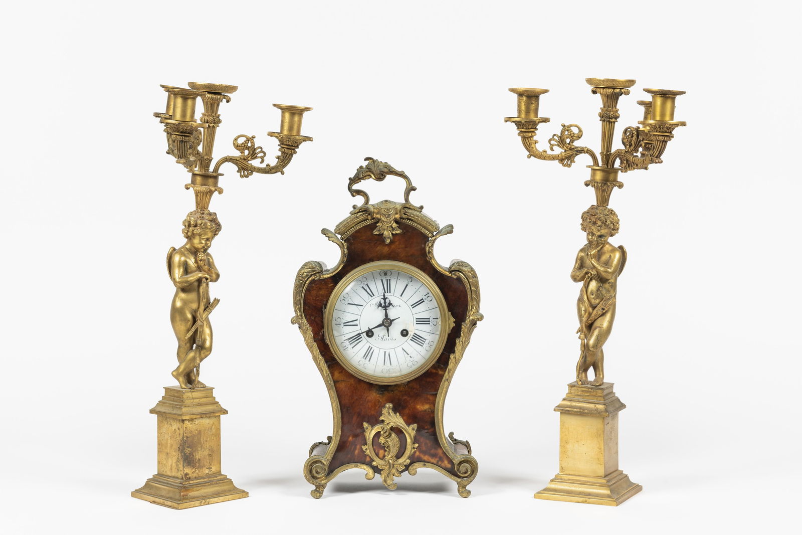 Cartel en bronze et écailles de tortue. Style Louis XV, 19e siècle: Cartel en bronze et écailles de tortue. Style Louis XV, 19e siècle A décor de rocailles. Cadran signé Martinot à Paris. (Accidents). On joint une paire de candélabres en