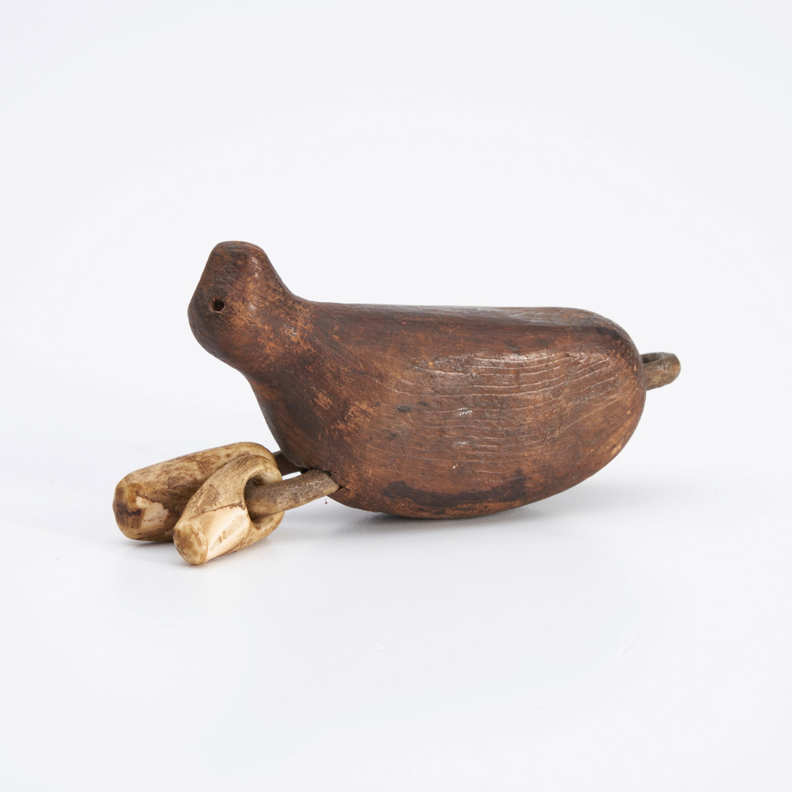 An Eskimo net float lg. 5 1/4 in.: An Eskimo net float 19th century, carved in the form of a seal, with attachments carved from walrus tusk. lg. 5 1/4 in. Footnotes: Provenance: Private collection, New York.