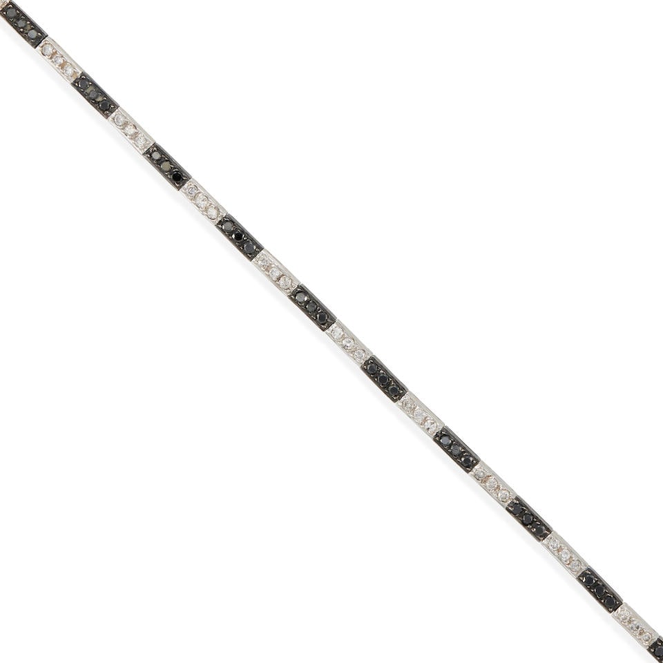 AN 18K WHITE GOLD, BLACK DIAMOND AND DIAMOND BRACELET: AN 18K WHITE GOLD, BLACK DIAMOND AND DIAMOND BRACELET • 18k white gold • 35 round diamonds weighing approximately 0.85 carat total and 36 round black diamonds • Length 7 1/4 in. R