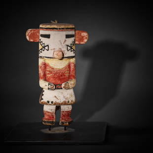 A Hopi katsina doll: A Hopi katsina dollLikely depicting Rugan or Corn katsina, depicted with arms bent at the elbows and held before the body, with serrated triangular elements painted on the sides of the face, the ears