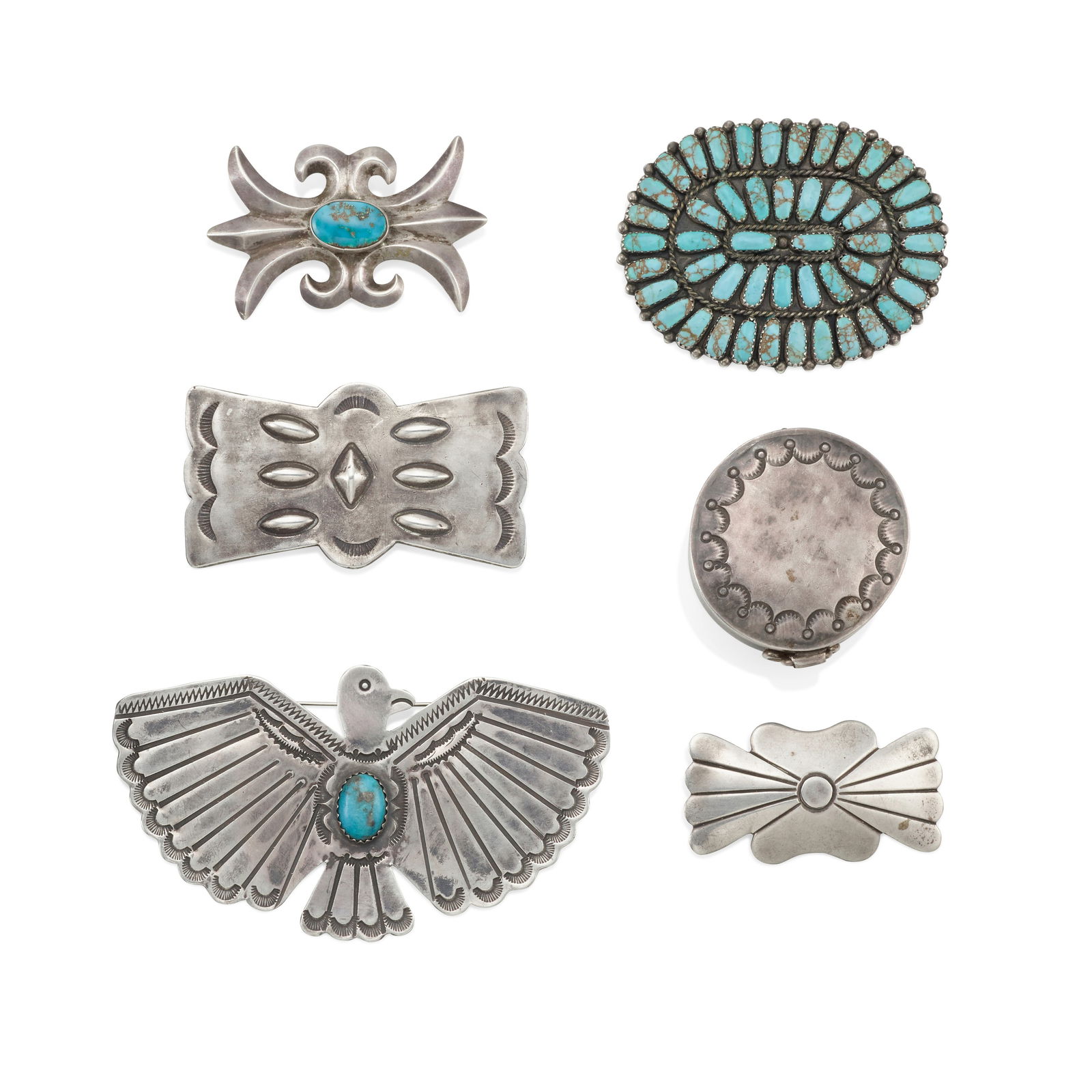 A collection of Diné (Navajo) or Zuni silver items: A collection of Diné (Navajo) or Zuni silver items Comprising five pins (three set with turquoise), and a circular pill box with hinged lid. eagle pin: width 4in; gross weight approximately 154.8