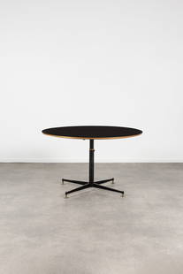 MOBILIER UNIVERSEL (attribué à) Table circulaire en bois avec plateau contrecollé...: MOBILIER UNIVERSEL (attribué à) Table circulaire en bois avec plateau contrecollé en formica noir, sur piètement en métal noir avec pieds en laiton, réglables en hauteur