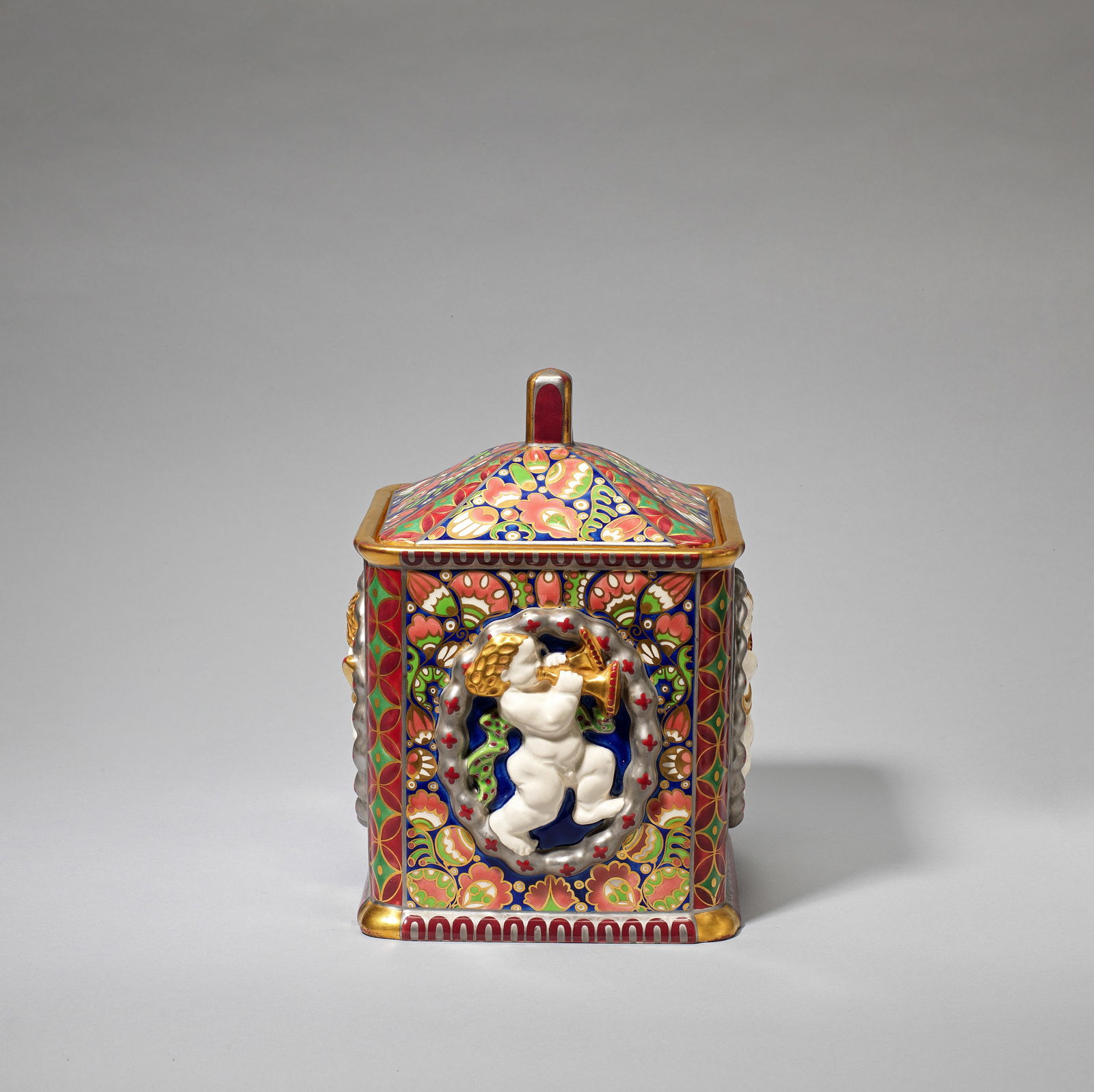 FRANZ STAUDIGL AND KARL KLAUS FOR ERNST WAHLISS 'Serapis' biscuit box and cover, model no. 10001...: FRANZ STAUDIGL AND KARL KLAUS FOR ERNST WAHLISS'Serapis' biscuit box and cover, model no. 10001, circa 1911Earthenware, decorated in relief with figural ovals with putti playing trumpets and horns, fu