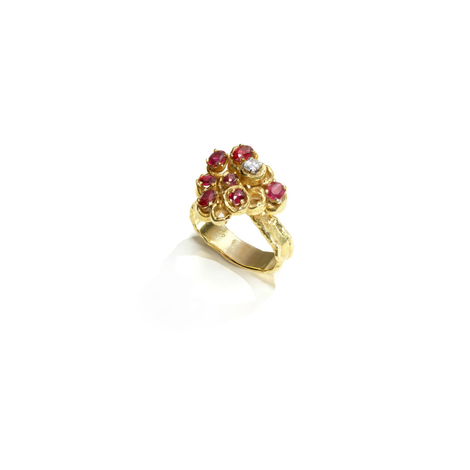 GRIMA: RUBY AND DIAMOND RING,: GRIMA: RUBY AND DIAMOND RING, 1986 The oval-cut and cushion-shaped rubies within undulating textured borders, with a brilliant-cut diamond accent, mounted in 18 carat gold, signed Grima, maker's mark
