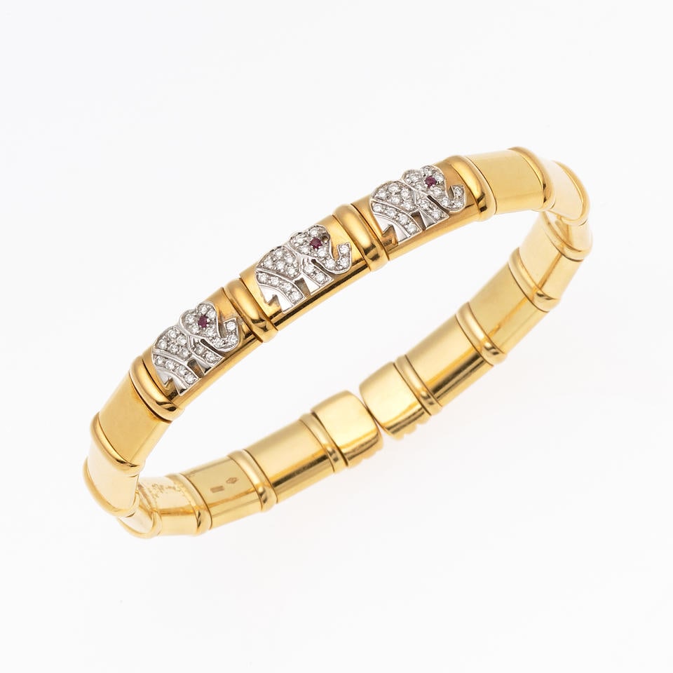 CHIMENTO: BRACELET OUVERT RUBIS ET DIAMANTS: CHIMENTO: BRACELET OUVERT RUBIS ET DIAMANTS Composé de maillons en or jaune à ressorts, accentué de trois motifs d'éléphants stylisés pavés de diamants de taille bri